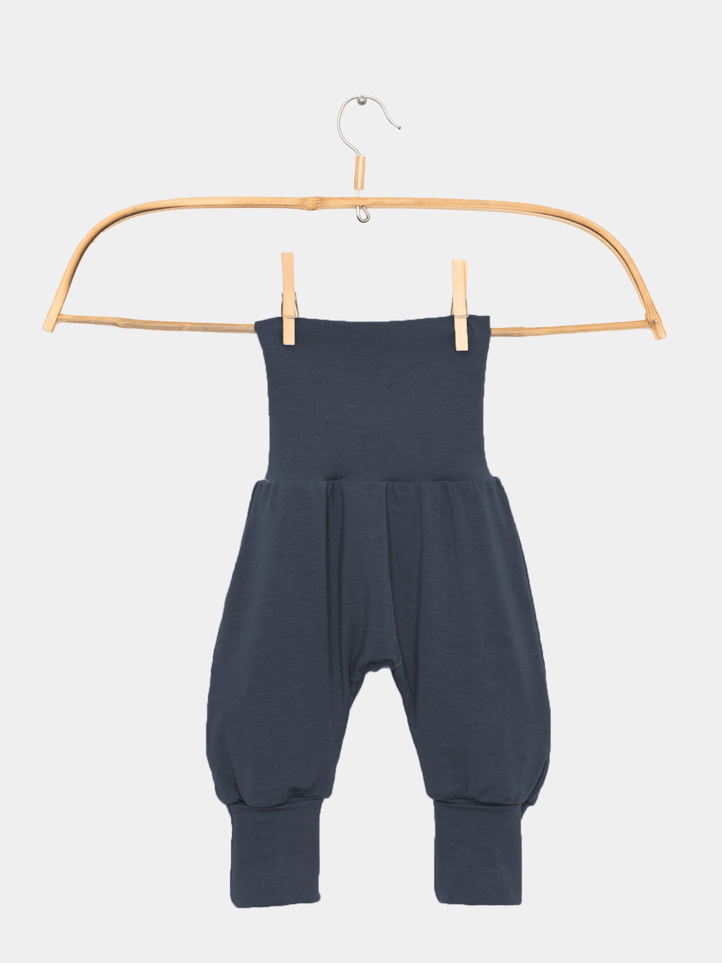 Babyknicker Kaschmir-Mix - Blaubeere, hängend an einem Holzbügel. Die Hose hat einen hohen Klappbund und schmale Knöchelbündchen, ideal für Neugeborene.