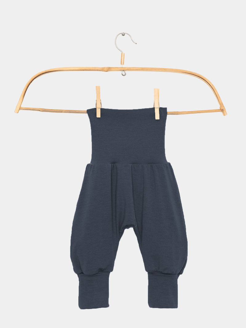 Babyknicker Kaschmir-Mix - Blaubeere, hängend an einem Holzbügel. Die Hose hat einen hohen Klappbund und schmale Knöchelbündchen, ideal für Neugeborene.