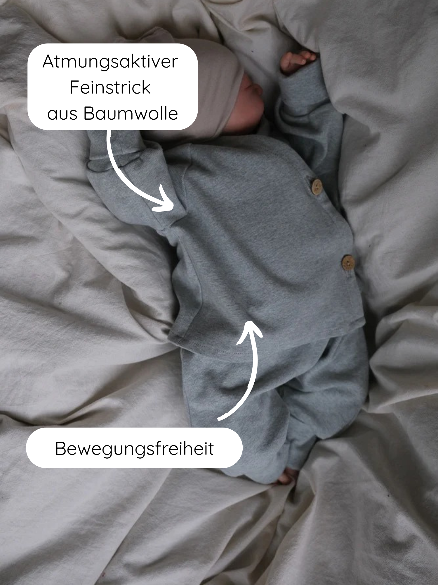 Babyschlüttli Feinstrick - Mint Meliert: Ein Baby trägt einen feinstrickigen, grauen Baumwollanzug mit Beanie auf neutraler Bettwäsche. Hervorgehoben werden atmungsaktiver Stoff und Bewegungsfreiheit.