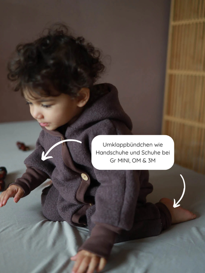Combinaison douillette en laine bouillie – mauve, avec des revers pratiques pour les petites mains et les petits pieds.
