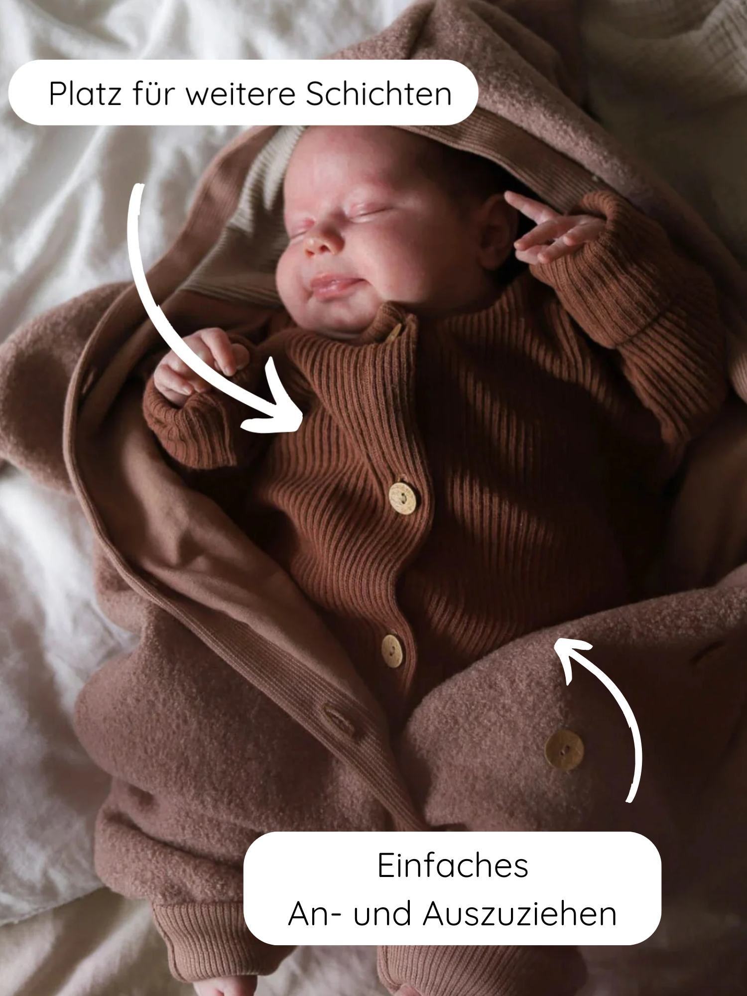 Schlafendes Baby im Kuschelanzug Wollwalk - Puder, eingehüllt in braune Schichten. Der Anzug zeigt eine Fleece-Optik mit Holzknöpfen, betont Komfort und einfache Handhabung durch deutsche Callouts.