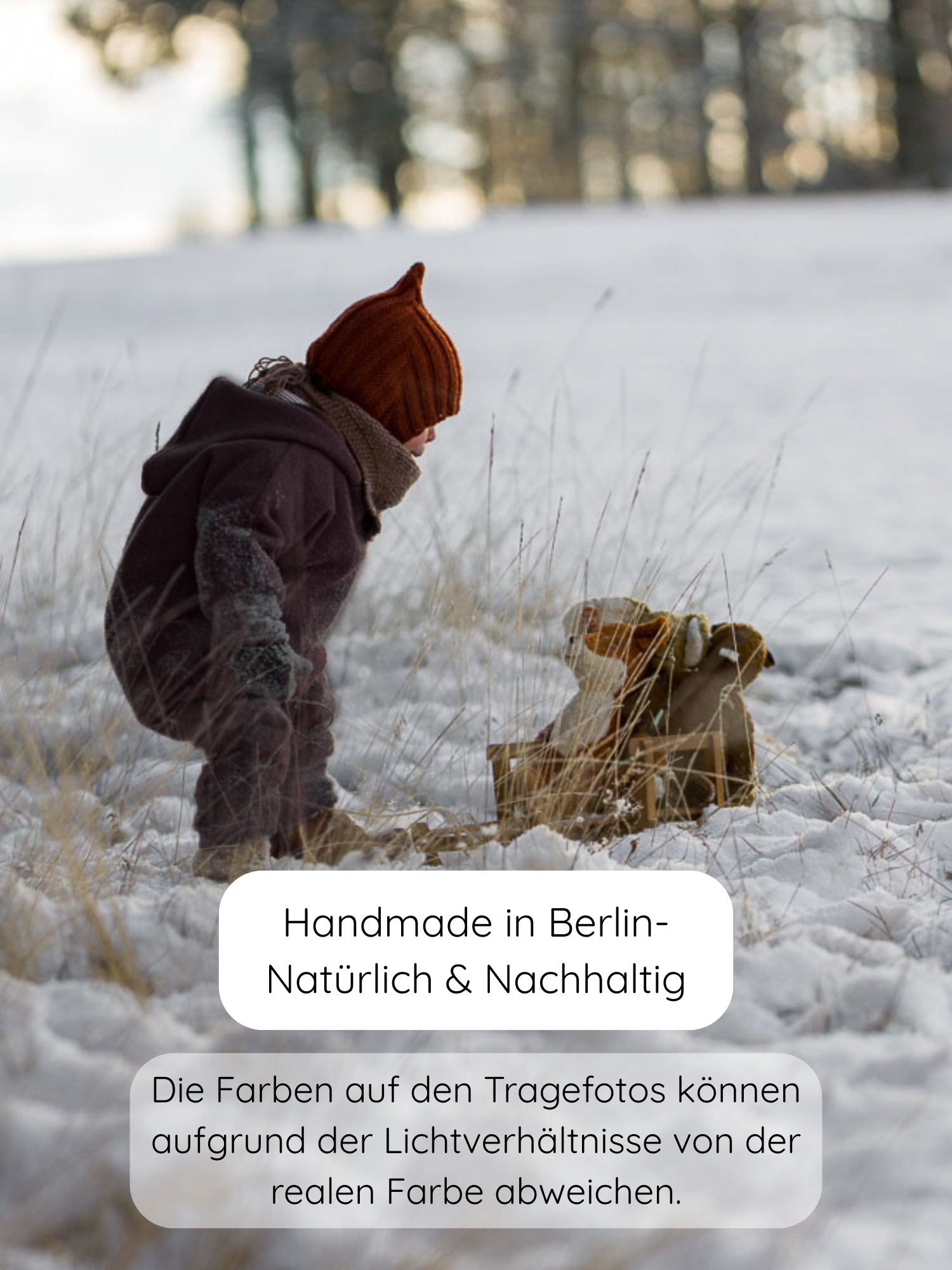 Kleinkind in Winter Wollwalk Overall mit Teddyfutter - Malve, kniet im Schnee neben Holzschlitten. Outfit mit Mütze, Schal, Fäustlingen; hält warm durch dicke Wollwalk-Außenschicht und flauschiges Innenfutter.