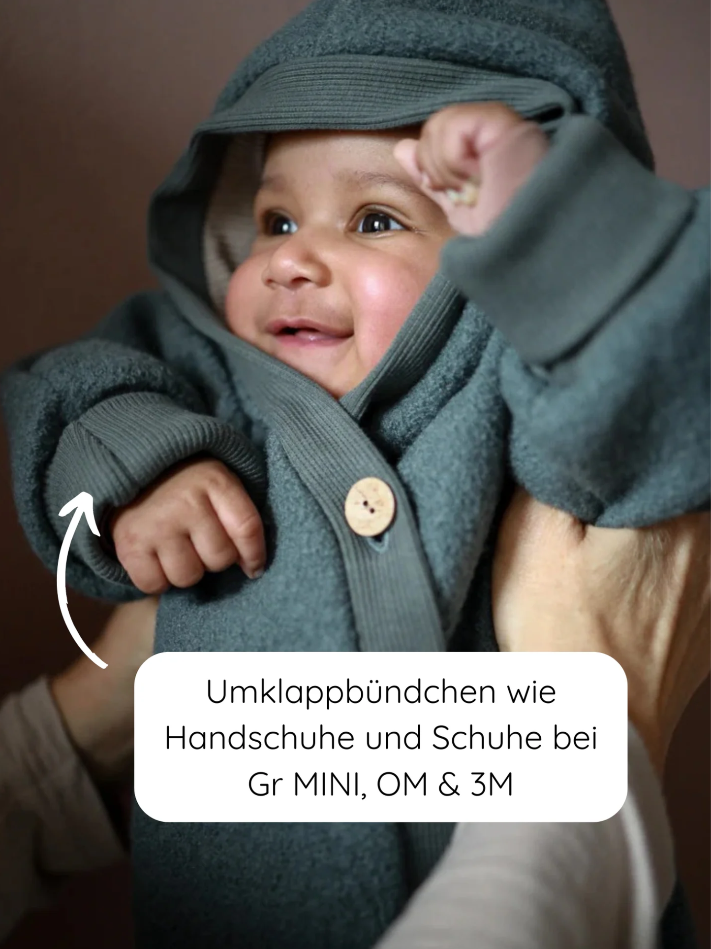 Kuschelanzug Wollwalk - Taube: Ein Baby trägt einen weichen, kapuzenbehafteten Jumpsuit mit Umklappbündchen, ideal als Handschuhe und Schuhe. Perfekt für Wärme und Schutz in kalten Jahreszeiten.