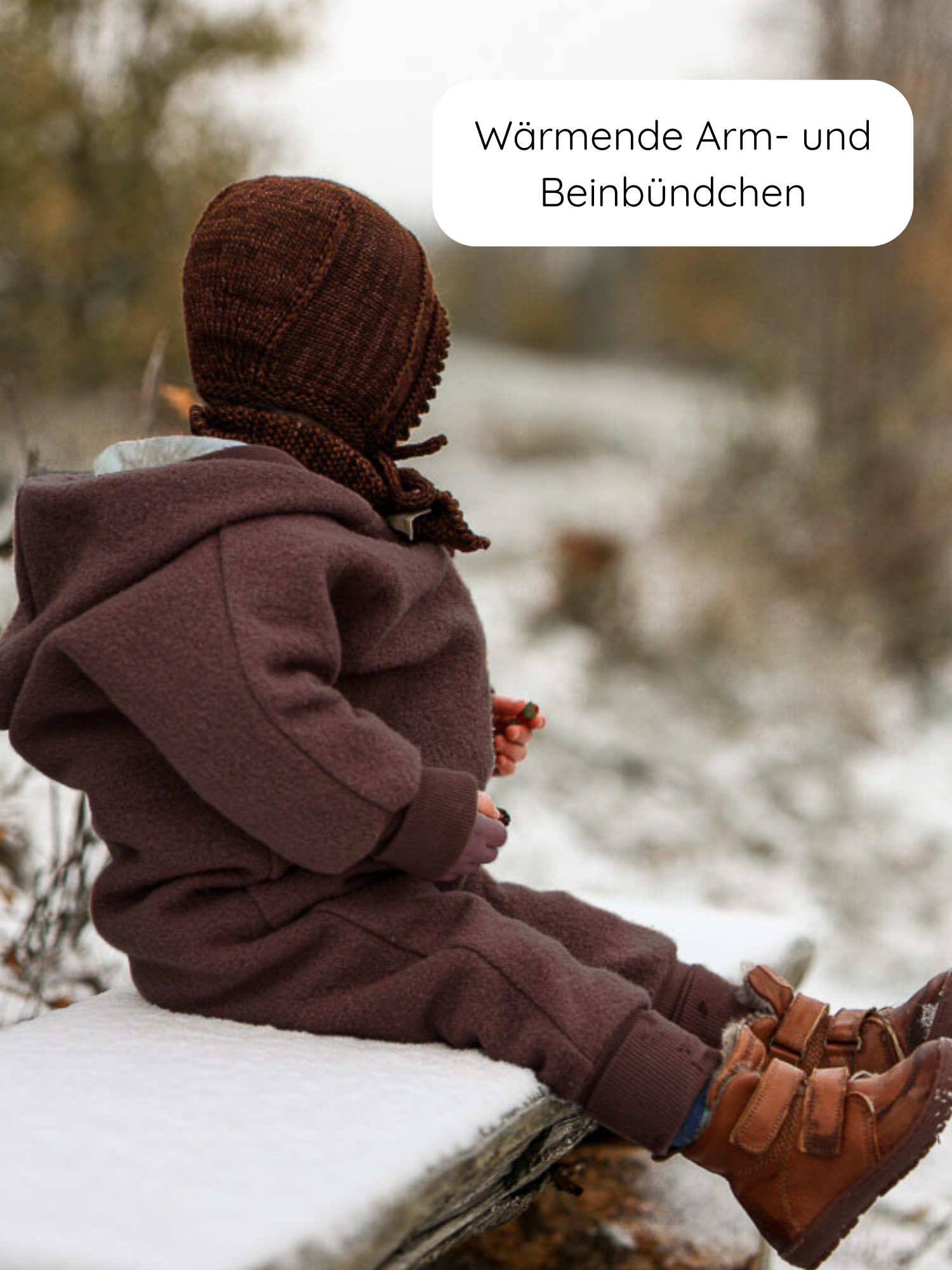 Kleinkind im Winter Wollwalk Overall mit Teddyfutter - Malve, sitzt auf schneebedeckter Bank. Trägt braunes Jumpsuit, handgestrickte Mütze, robuste Lederstiefel. Hervorgehobene Bündchen wärmen Arme und Beine.