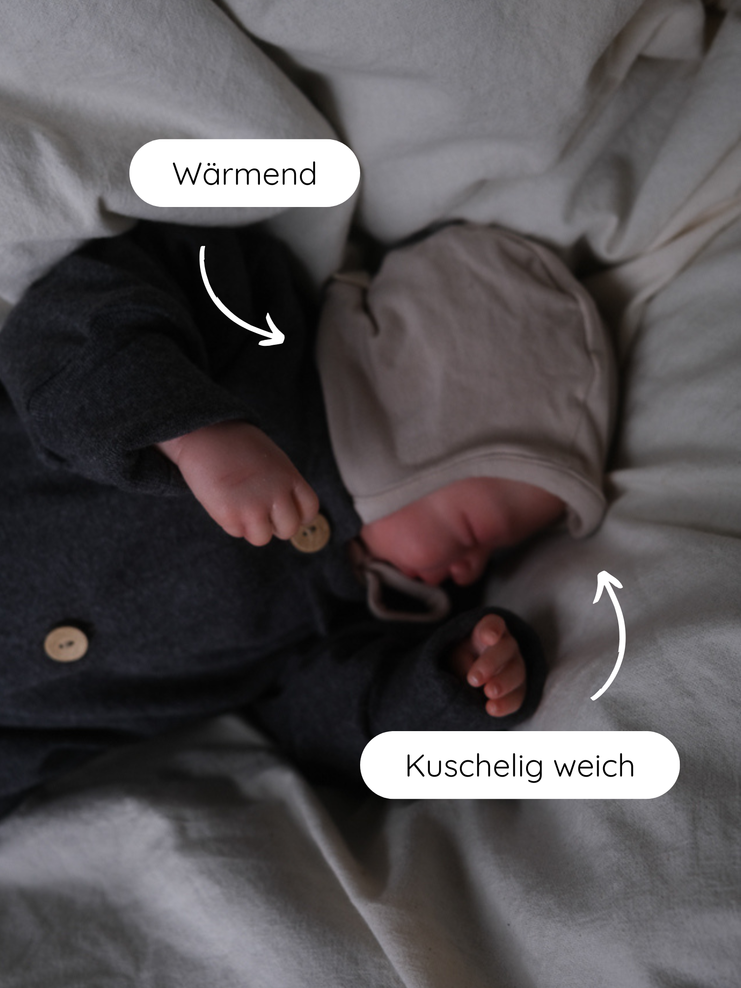 Ein schlafendes Neugeborenes trägt ein Babyhäubchen Kaschmir-Mix - Sand, das warm und kuschelig weich ist, mit extralangen Bändern auf einem weichen, hellen Untergrund liegend.