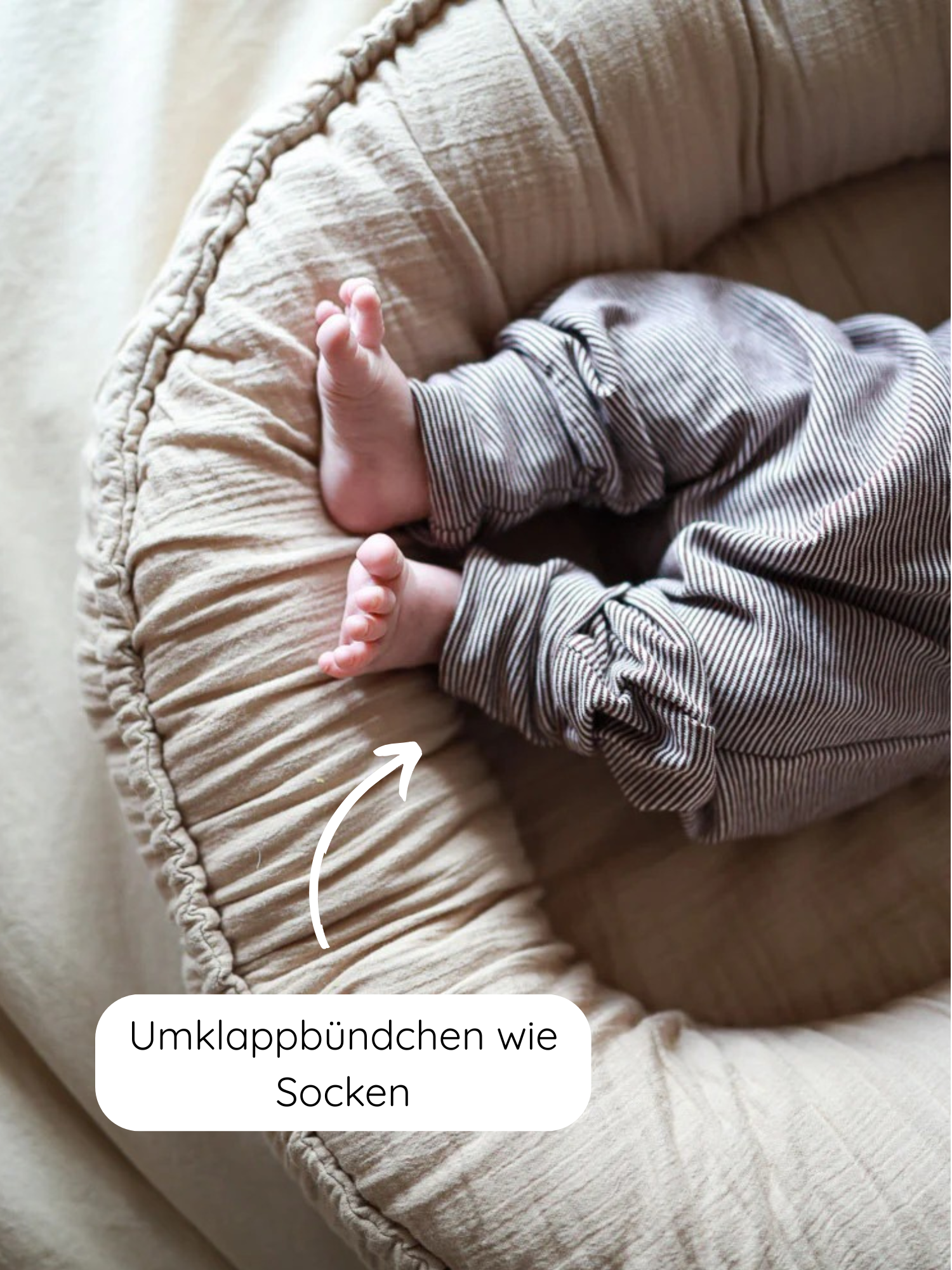 Nahaufnahme der Babyknicker Bio-Baumwolle - Schoko Ringel mit umklappbaren Beinabschlüssen. Zeigt Babybeine in gestreiften Hosen auf einem Nest. Elastische Bündchen für sanften Sitz und Bewegungsfreiheit.
