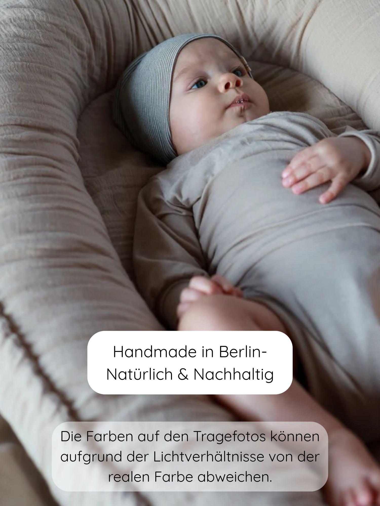 Säugling liegt in einem weichen „Baby Nest“ und trägt die Beanie Bio-Baumwolle - Ringel Maus, eine elastische, nahtlose Mütze aus 100% Bio-Baumwolle, ideal für empfindliche Kinderhaut.
