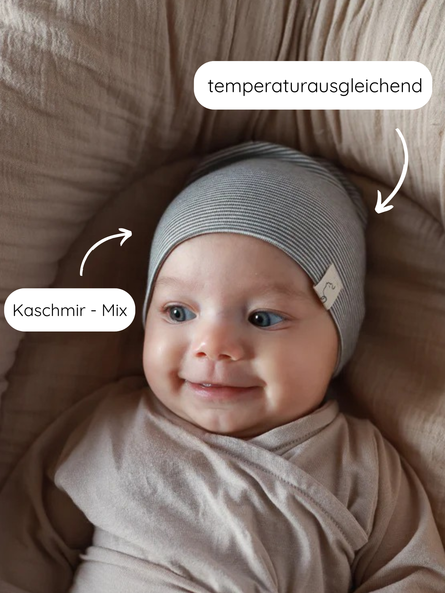 Nahaufnahme eines lächelnden Babys in einem weichen, gestreiften Beanie Bio-Baumwolle - Ringel Maus aus Kaschmir-Mix, das temperaturausgleichend wirkt und ideal für empfindliche Kinderhaut ist.