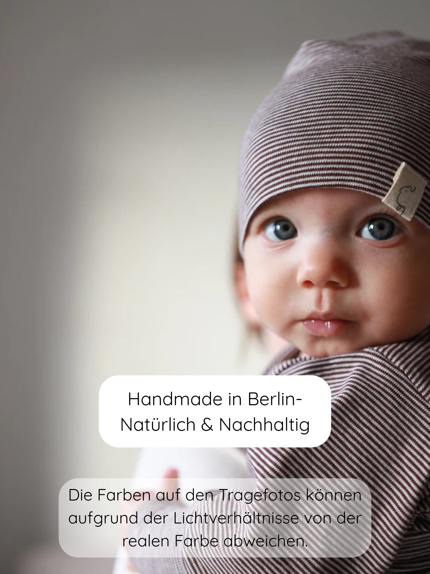 Nahaufnahme eines Babys mit Beanie Bio-Baumwolle - Ringel Schoko, eine weiche Mütze aus Bio-Baumwolle, handgefertigt in Berlin, mit dezenter Streifenoptik und passendem Tragetuch.