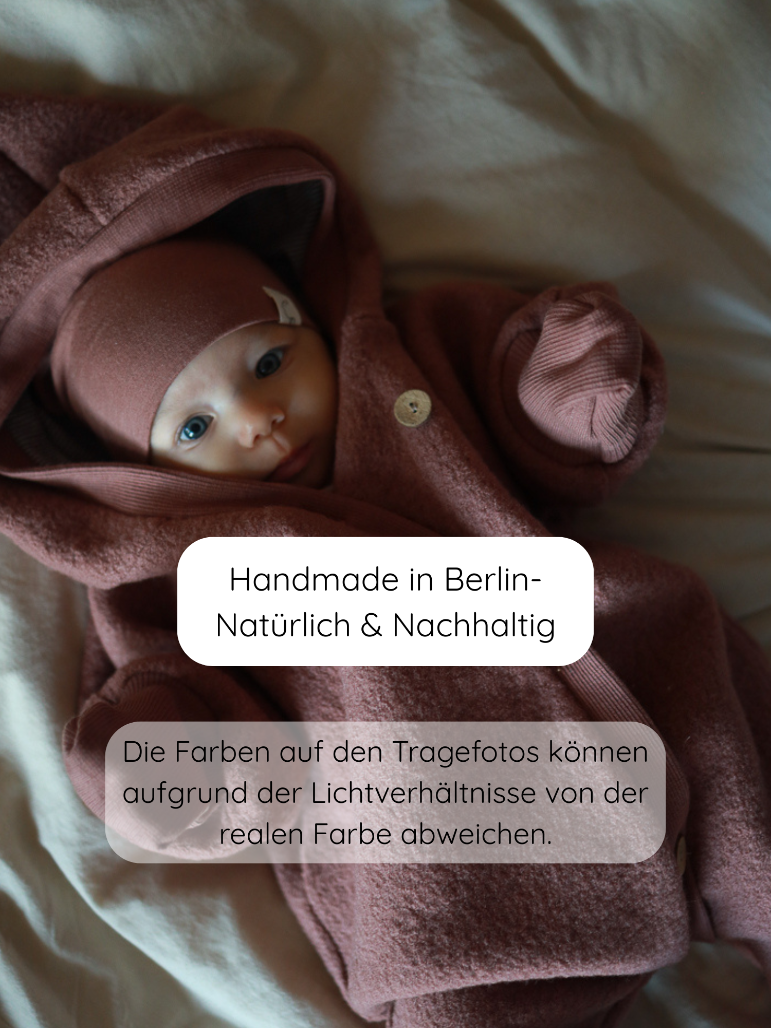 Kleinkind in Beanie Kaschmir-Mix - Zimt, staubrosafarbener Overall und Mütze, liegt auf hellem Untergrund. Die Beanie ist atmungsaktiv und sanft zur Babyhaut, ideal für Neugeborene.