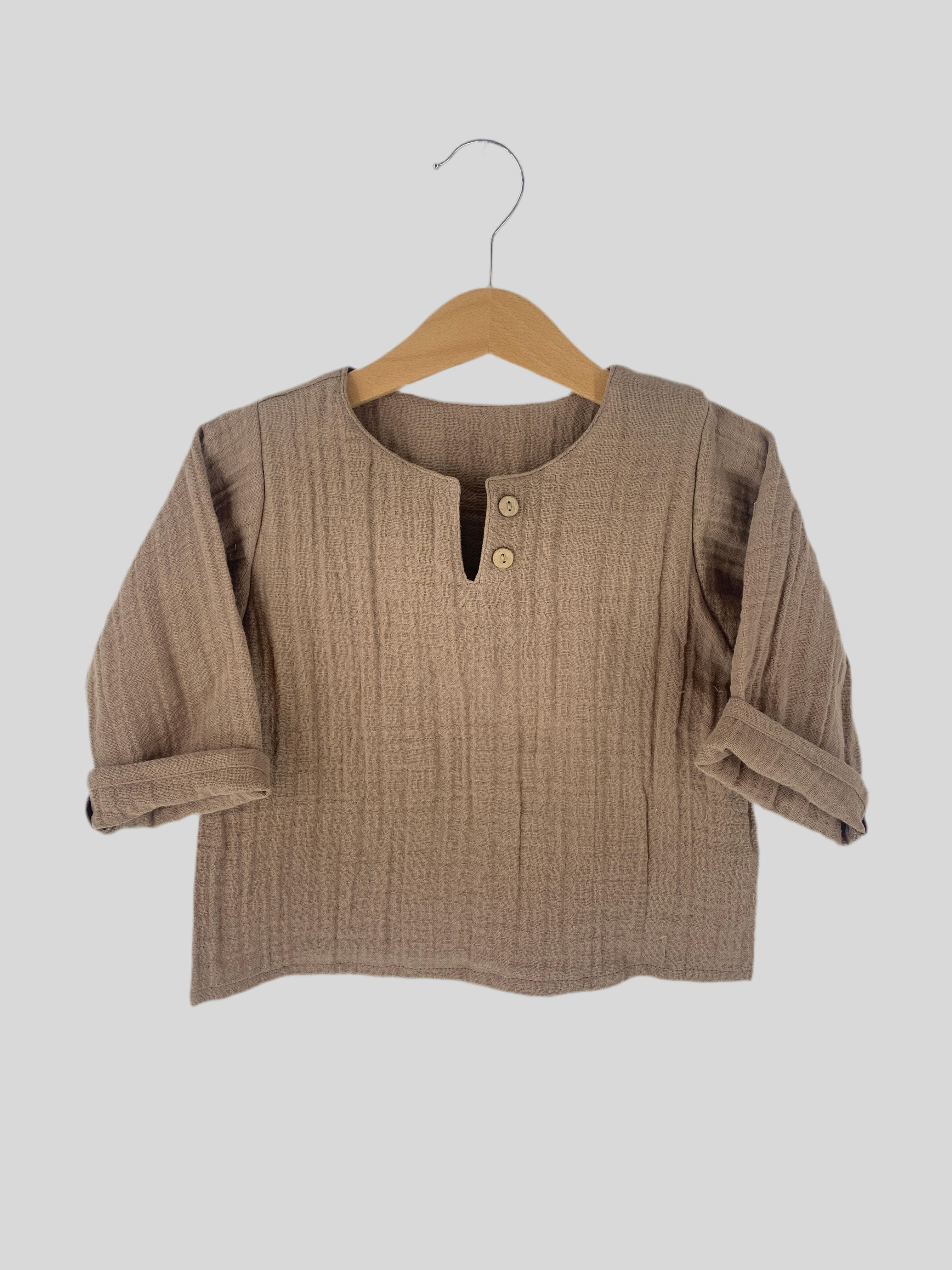 Hemdchen Musselin Schlamm Gr. 1Y, neu, zeigt ein weiches Musselin-Material mit zarten Stofffalten, ideal für Kleinkinder. Perfekte Passform für einjähriges Kind, betont durch schlichtes Design.