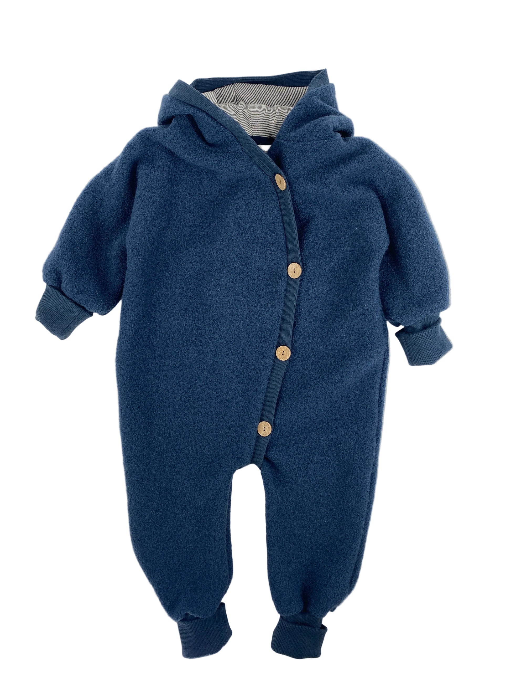 Babyknicker Sweat Cremepuder Gr Mini: Ein einteiliger, fleeceartiger Baby-Strampler mit Kapuze, langen Ärmeln, gerippten Bündchen und diagonalen Knöpfen. Zustand: sehr gut.
