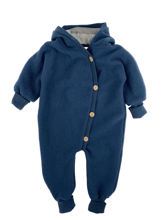 Babyknicker Sweat Cremepuder Gr Mini: Ein einteiliger, fleeceartiger Baby-Strampler mit Kapuze, langen Ärmeln, gerippten Bündchen und diagonalen Knöpfen. Zustand: sehr gut.