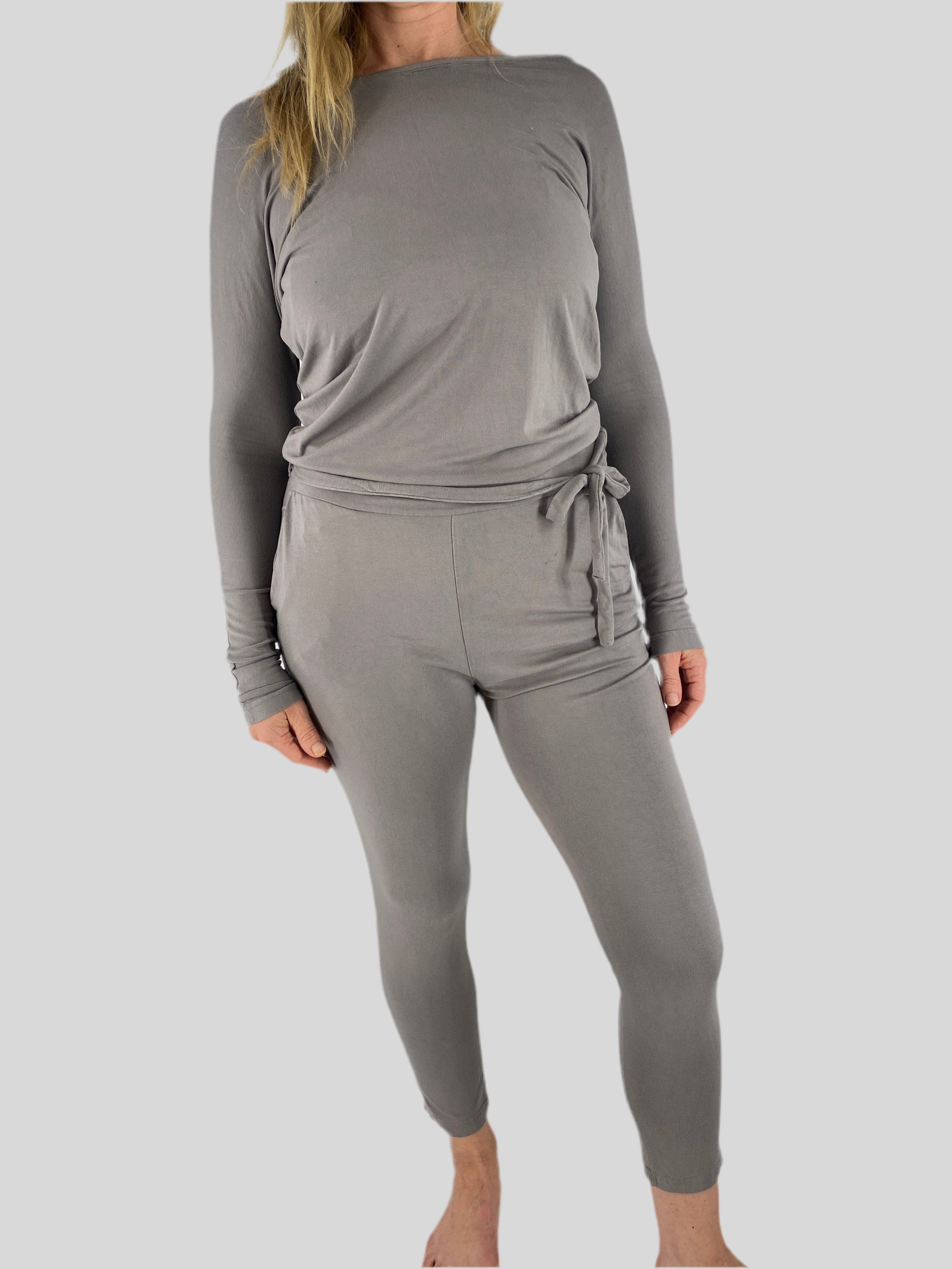 Jumpsuit Bio-Jersey hellgrau Gr S: Person trägt einen hellgrauen, langärmeligen Wickel-Top mit Taillenband und passenden eng anliegenden Leggings. Naht locker am Halsausschnitt und kleiner Fleck vorne.