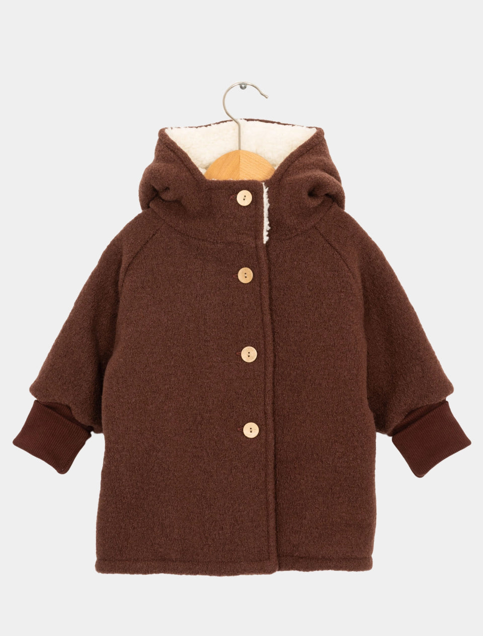 Teddy-Wichteljacke Wollwalk Puder Gr 12/13Y: Kinderjacke aus weichem, flauschigem Stoff mit Sherpa-Kapuze, Holzknöpfen vorne und gerippten Bündchen, Größe 158-170, präsentiert auf Holzkleiderbügel.