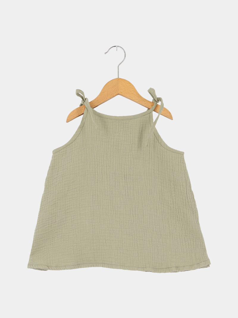 Hängerchen Musselin - Salbei: Ein luftiges, salbeigrünes Musselin-Hängerchen mit verstellbaren Schulterbändern, auf einem Holzkleiderbügel hängend, ideal als wachstumsfähiges Kleid oder Oberteil für Kinder.
