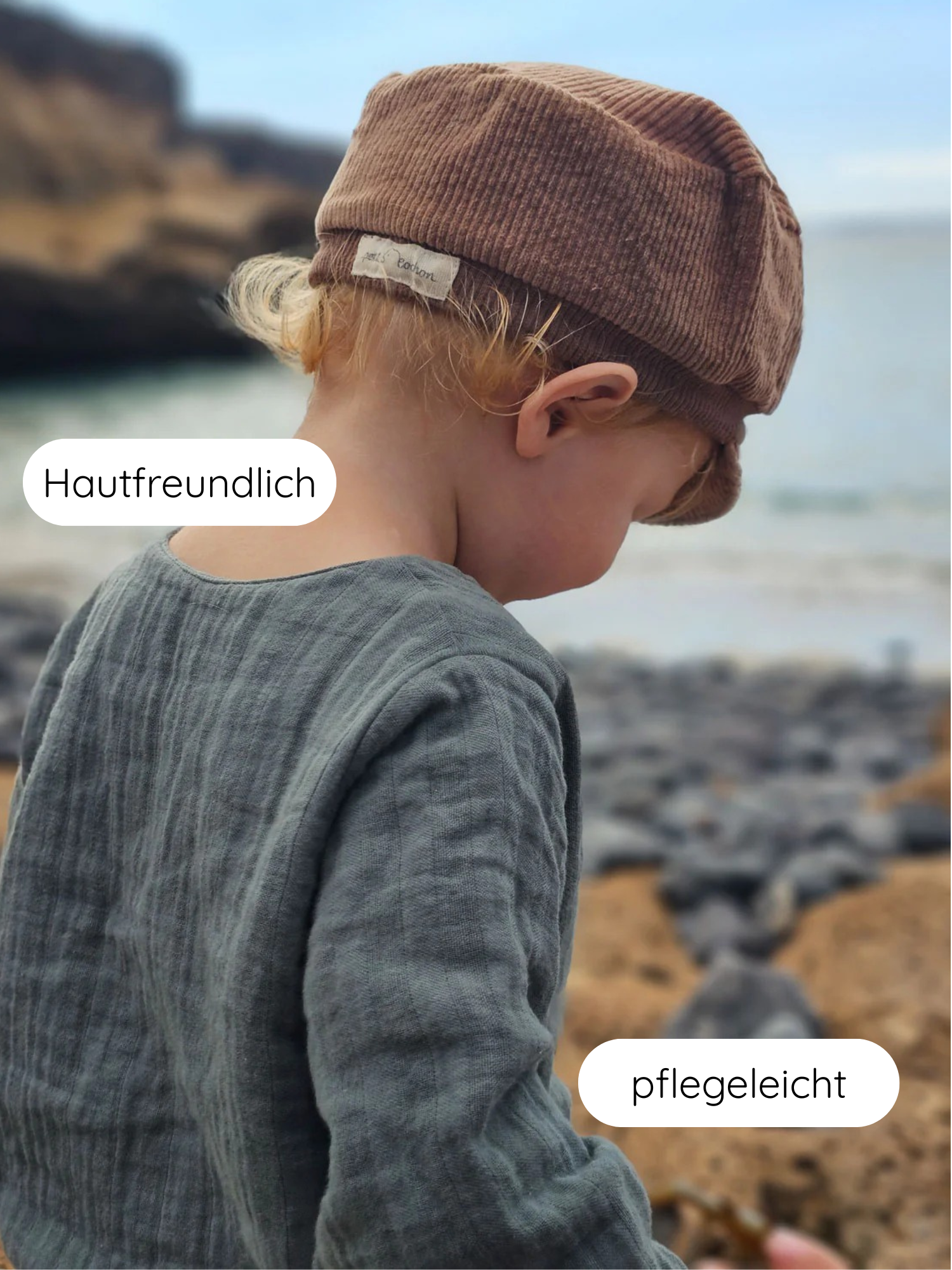 Kleinkind am Strand trägt Hemdchen Musselin - Eisblau. Leicht und atmungsaktiv, ideal für warme Tage. Hautfreundlich, pflegeleicht, mit lockerer Passform für Bewegungsfreiheit. Hergestellt in Berlin.