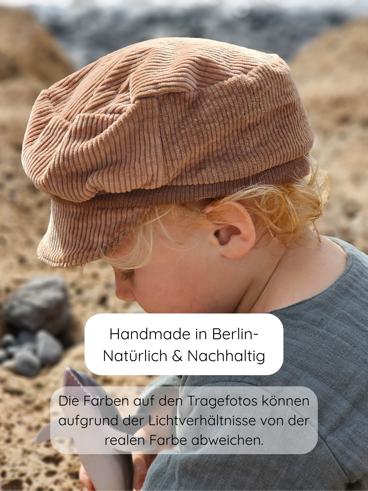 Kleinkind mit beige Newsboy-Mütze spielt im Sand, trägt Hemdchen Musselin - Eisblau, leicht und atmungsaktiv, ideal für warme Tage. Hergestellt in Berlin, handgefertigt und nachhaltig.