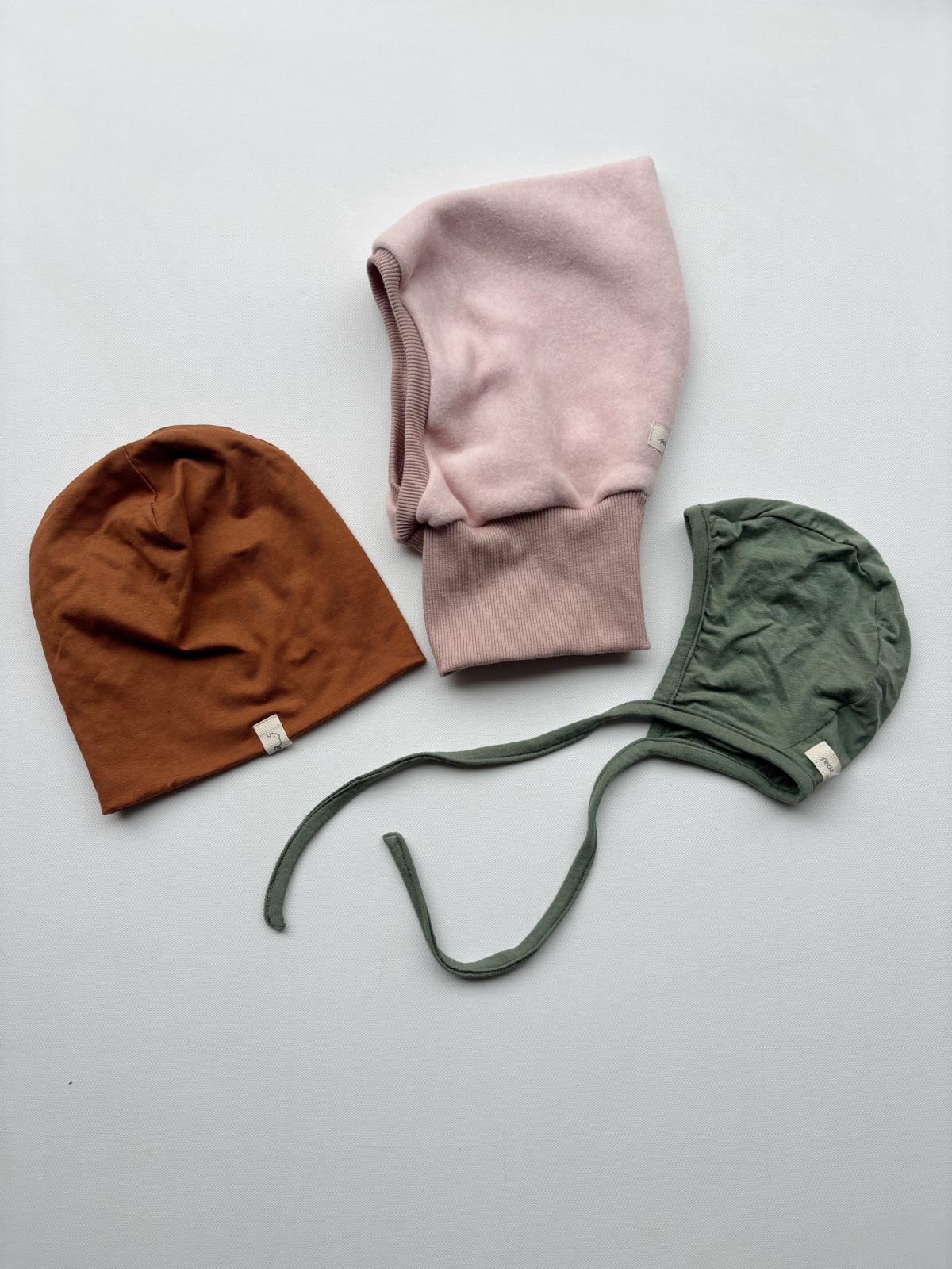 Set 1 Beanie, Schlupfmütze und Häubchen in Gr 6M, dargestellt auf einer weißen Oberfläche mit einem Elefantenetikett, präsentiert als modisches Accessoire für Kleinkinder. 