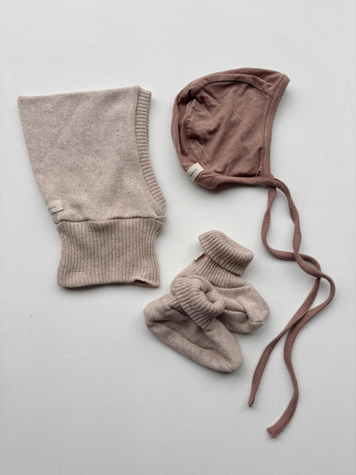 Set 2 Schlupfmütze, Schühchen und Häubchen in Gr 6M-2Y, präsentiert auf weißem Hintergrund. Nahaufnahme von gestrickten Details und Etikett sichtbar. Ideal für Babys von 6 Monaten bis 2 Jahren.