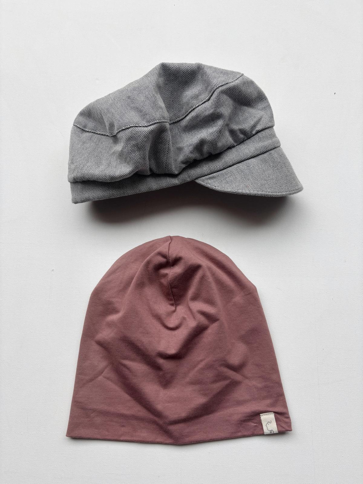 Set 9 Michelmütze und Beanie in Gr S-L auf weißem Untergrund. Zeigt eine graue Michelmütze und eine rote Beanie, beide als modische Accessoires aus Textil.