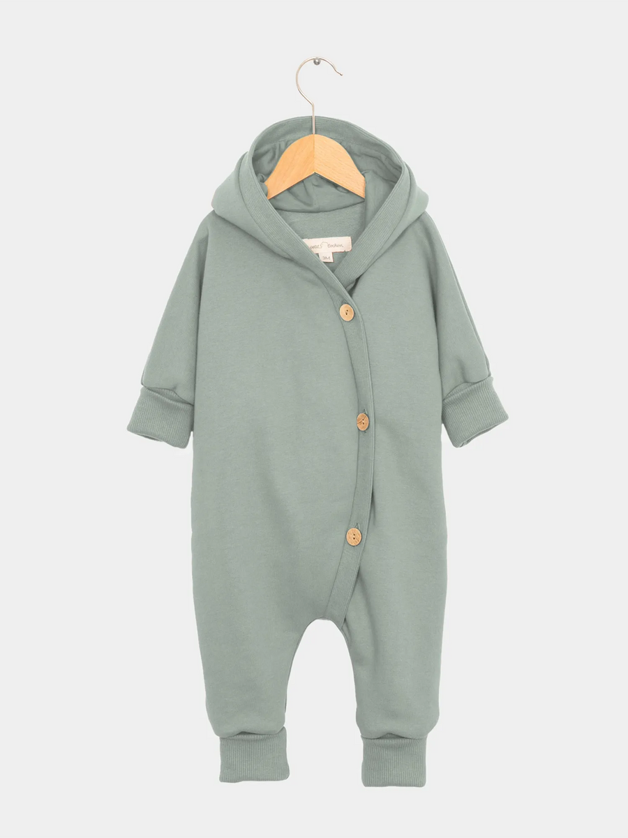 Babyknicker Kaschmir Mix Sand Gr 0M auf einem Schaukelstuhl, zeigt einen grauen Babystrampler mit Knöpfen. Zustand: sehr gut, mit Hinweis auf leicht festem Bauchbundgummi.