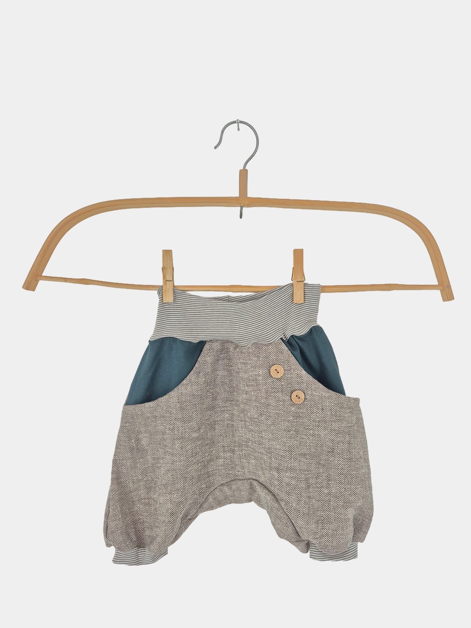 Kopie Kurze Knickerbocker Fischgrat Petrol Gr 1Y: Eine Knickerbocker-Hose auf einem Kleiderbügel mit Holzgriff, präsentiert auf einer Schaukel und an einer Wäscheleine hängend, Zustand: neu.