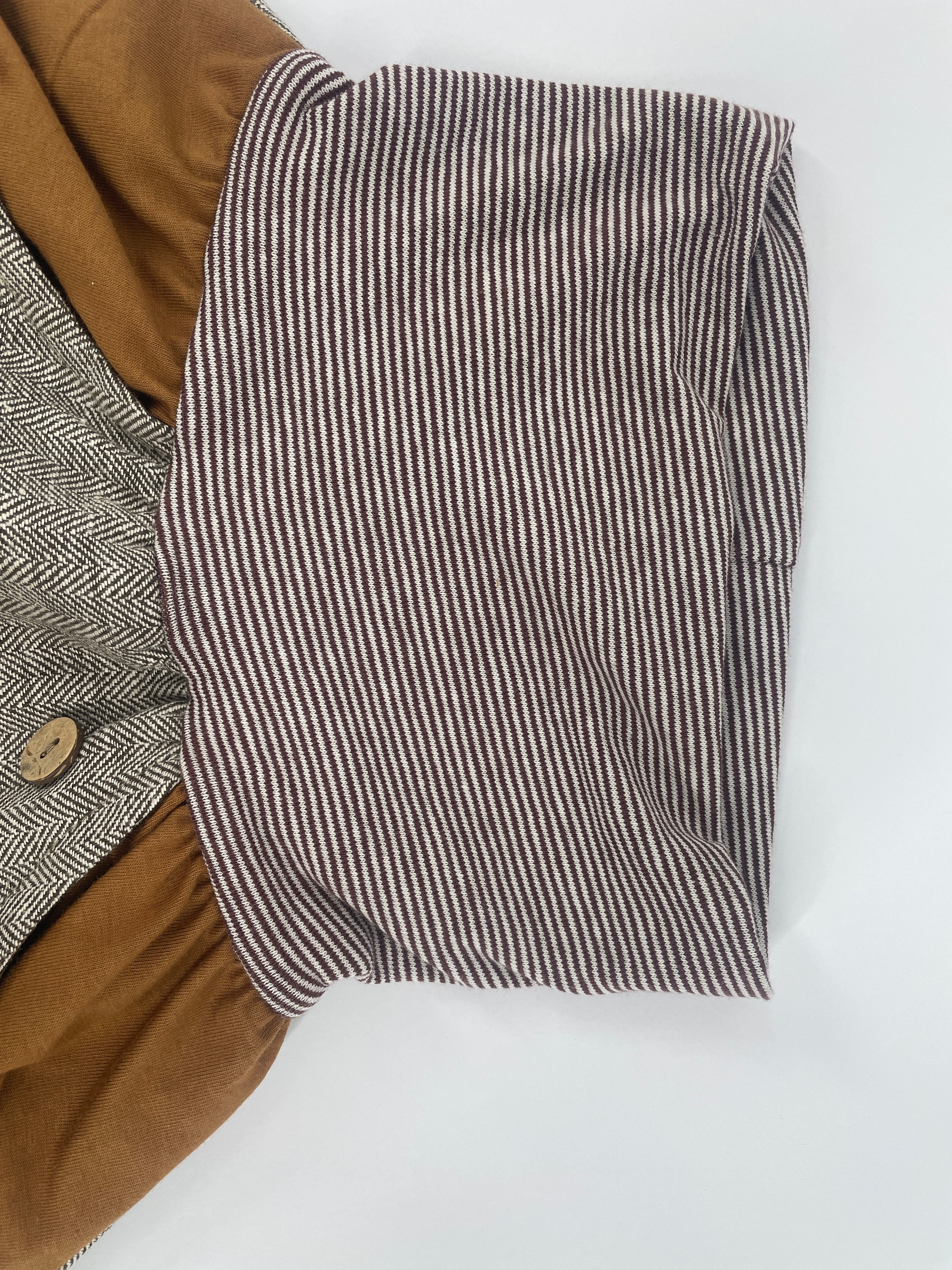 Nahaufnahme des Knickerbocker Fischgrat Sahara Gr. 1, die ein feines Fischgrätenmuster und sorgfältige Nähte zeigt, ideal für modische Kleidung. Zustand: neu mit braunem Ringel Bündchen.