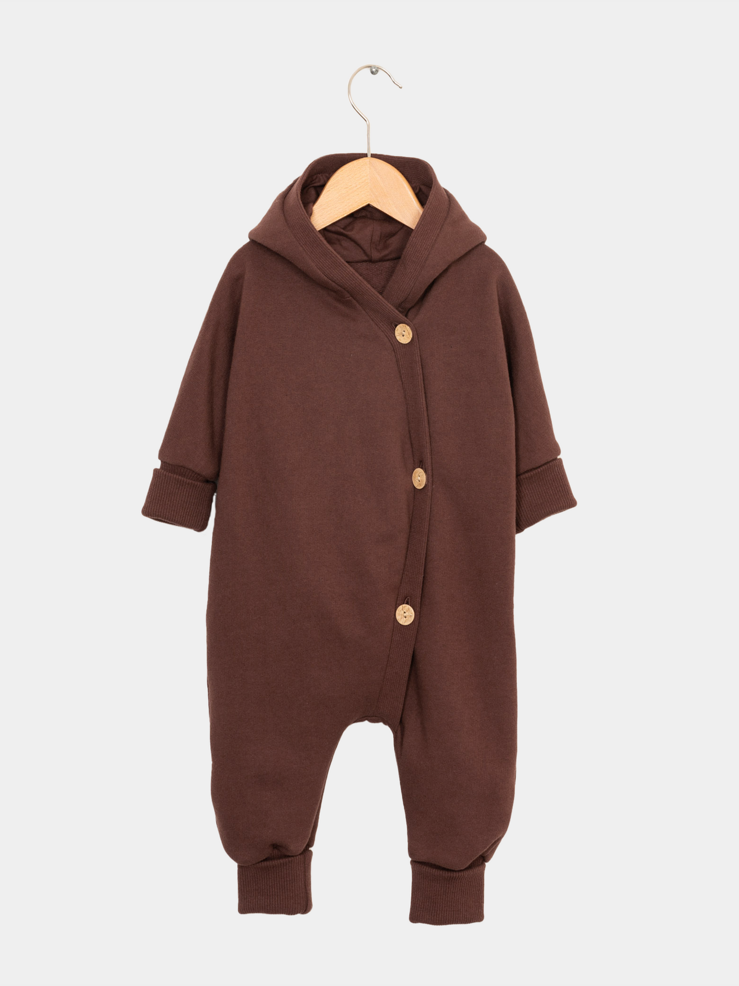 Nahaufnahme des Kuschelanzugs Bio-Sweat - Schoko auf einem Kleiderständer, mit gekrempelten Bündchen an Armen und Beinen, ideal für Babys und Kinder durch seinen weichen, angerauten Innenstoff aus Bio-Baumwolle.
