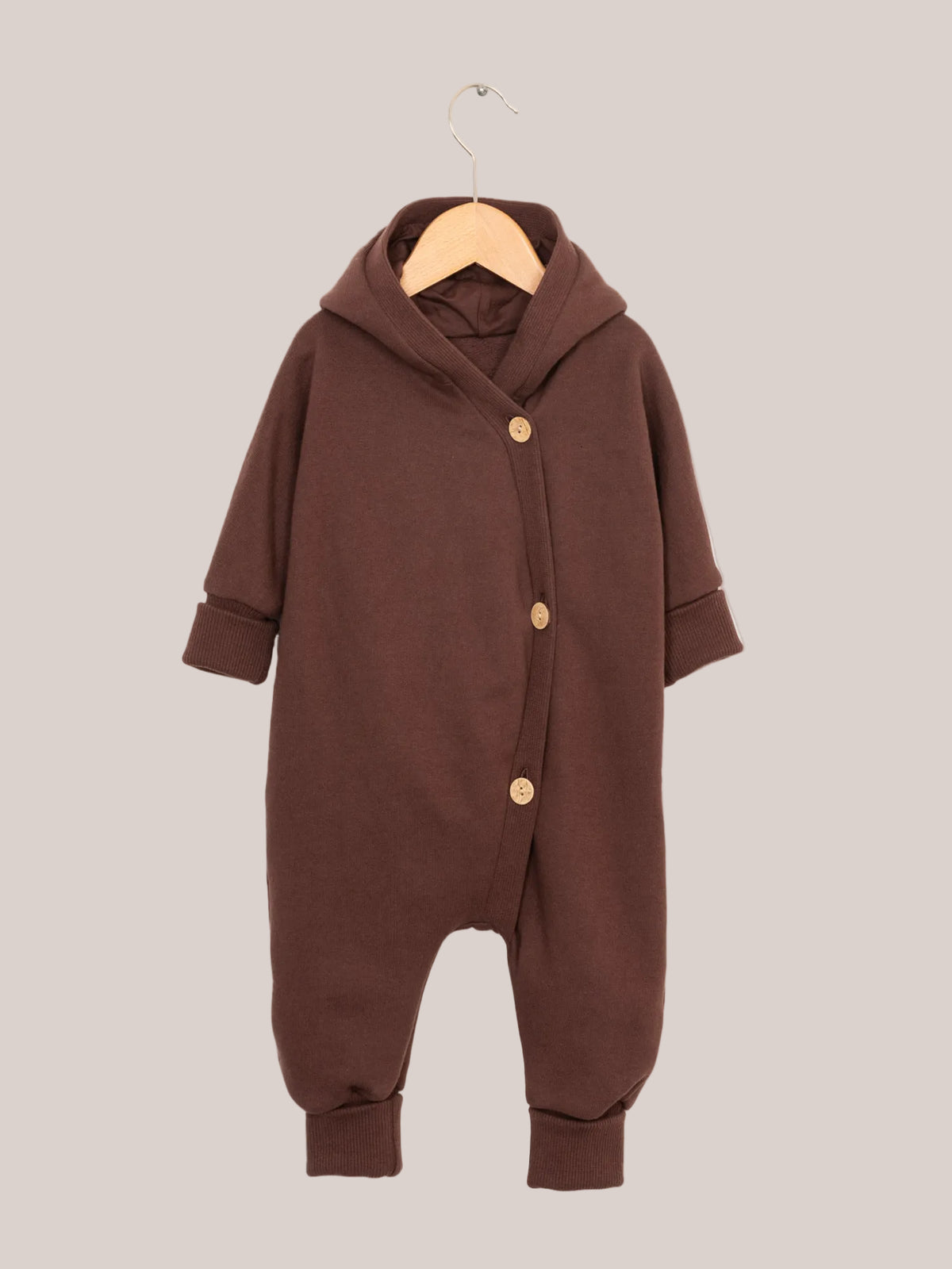 Nahaufnahme des Kuschelanzugs Bio-Sweat - Schoko auf einem Kleiderständer, mit gekrempelten Bündchen an Armen und Beinen, ideal für Babys und Kinder durch seinen weichen, angerauten Innenstoff aus Bio-Baumwolle.