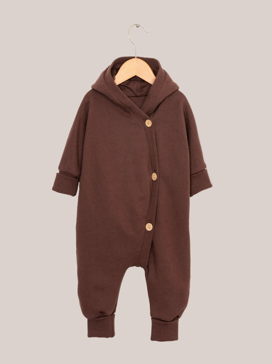 Nahaufnahme des Kuschelanzugs Bio-Sweat - Schoko auf einem Kleiderständer, mit gekrempelten Bündchen an Armen und Beinen, ideal für Babys und Kinder durch seinen weichen, angerauten Innenstoff aus Bio-Baumwolle.