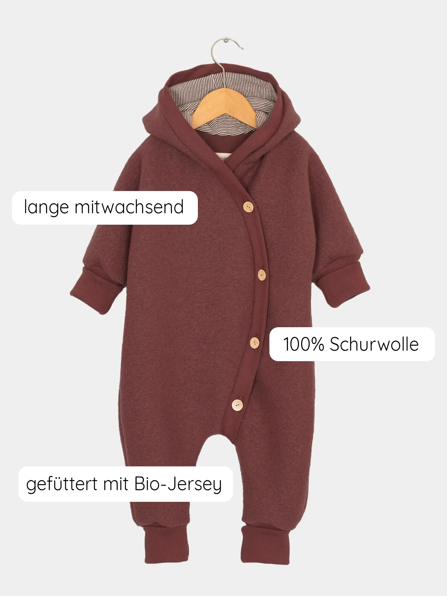 Kuschelanzug Wollwalk - Ziegel: Ein einteiliger Baby-Overall aus 100% Schurwolle mit Bio-Jersey-Futter, langen Ärmeln, Kapuze, integrierten Füßen und einem versetzten Knopfverschluss, mitwachsend durch umklappbare Bündchen.