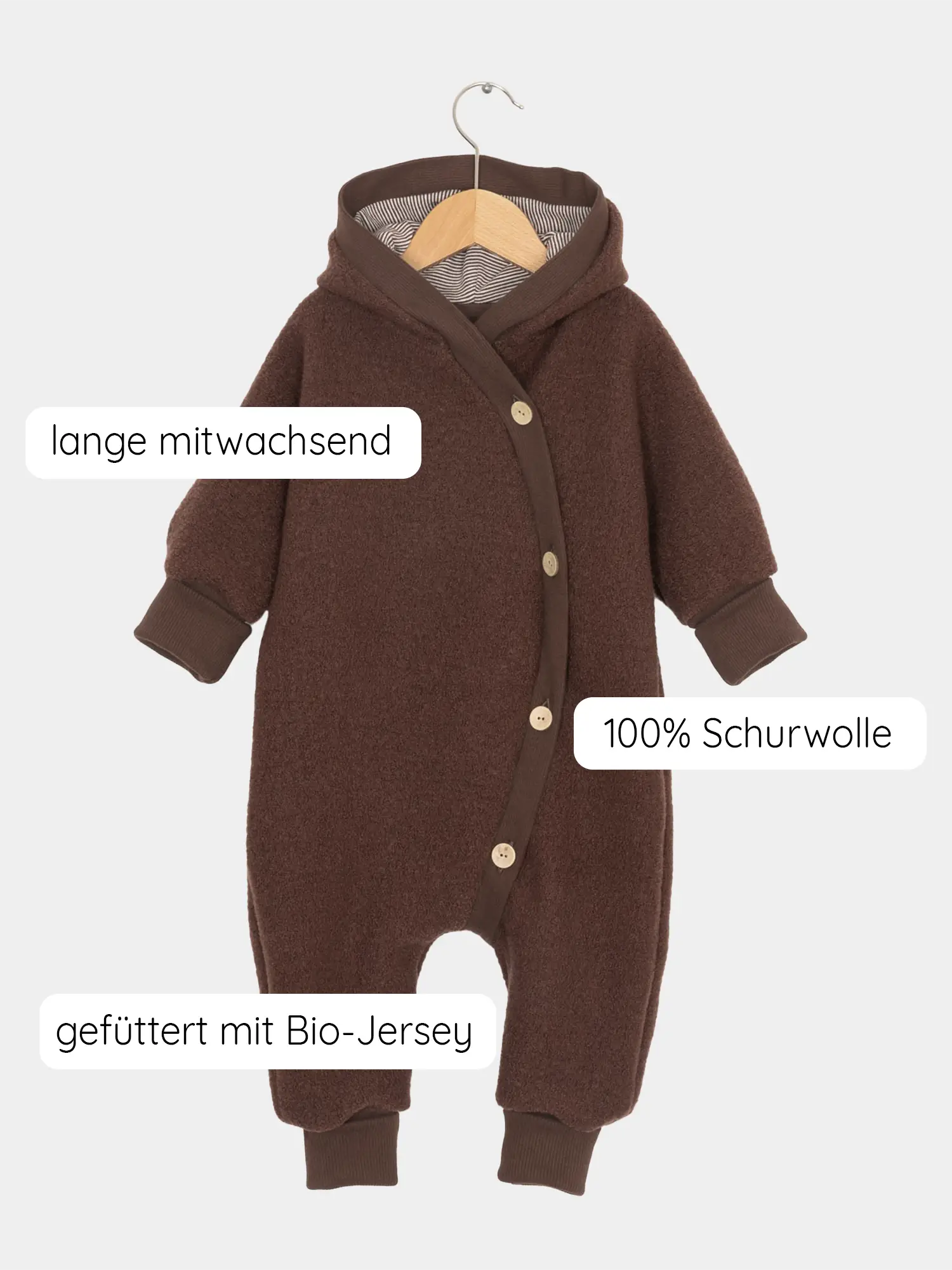Kuschelanzug Wollwalk - Schoko: Tiefbrauner Baby-Overall aus 100% Schurwolle, gefüttert mit Bio-Jersey. Mitwachsend durch lange, krempelbare Bündchen, seitlich versetzte Knopfleiste, ideal für kühle Tage. Hängend auf Holzkleiderbügel.