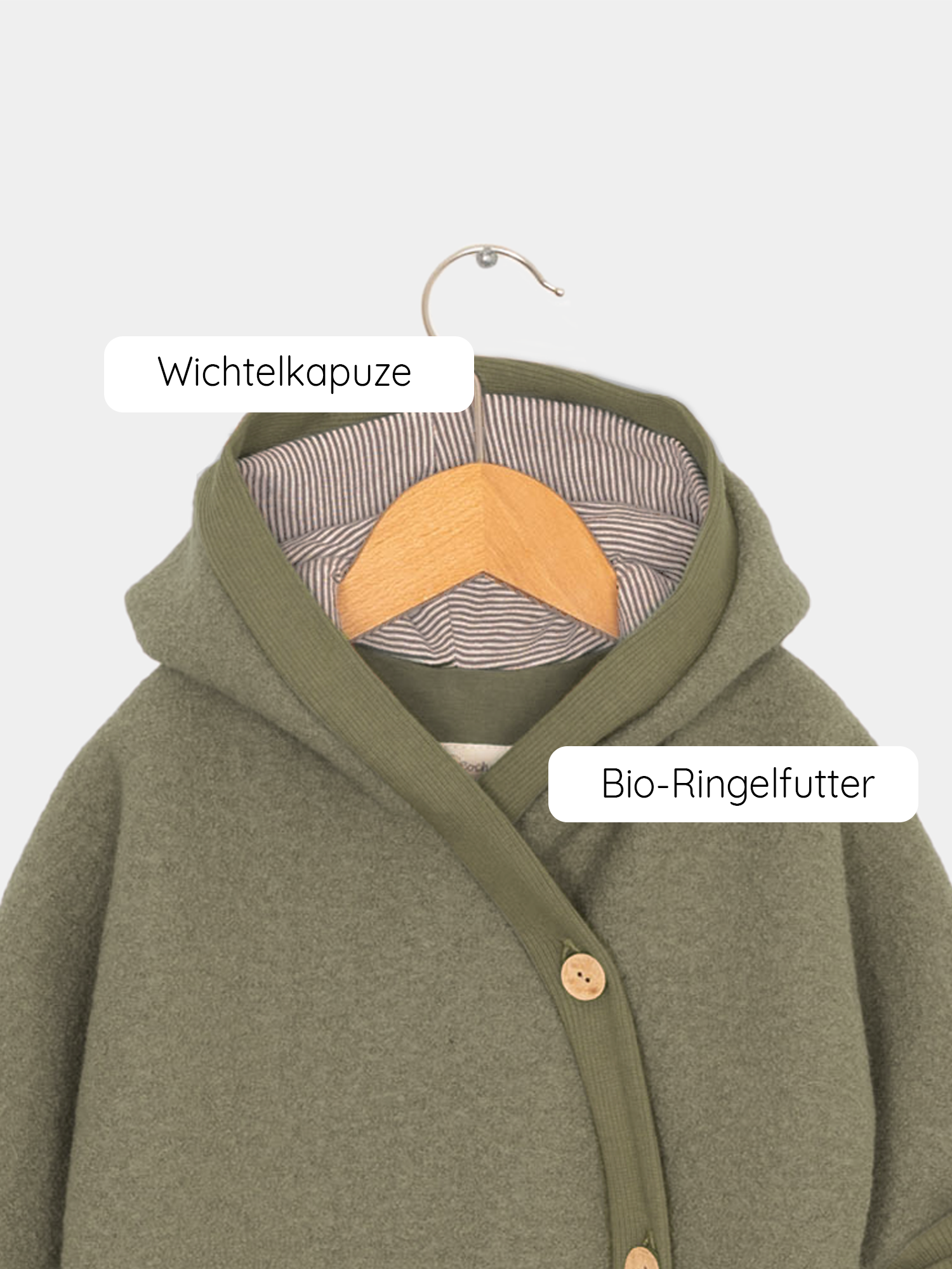 Kuschelanzug Wollwalk - Pistazie, hängend auf einem Holzbügel, zeigt einen grünen Overall mit Kapuze und Ringelfutter, ideal für kühle Jahreszeiten mit eng anliegenden Bündchen für optimalen Schutz. Wollwalk Anzug für Kinder