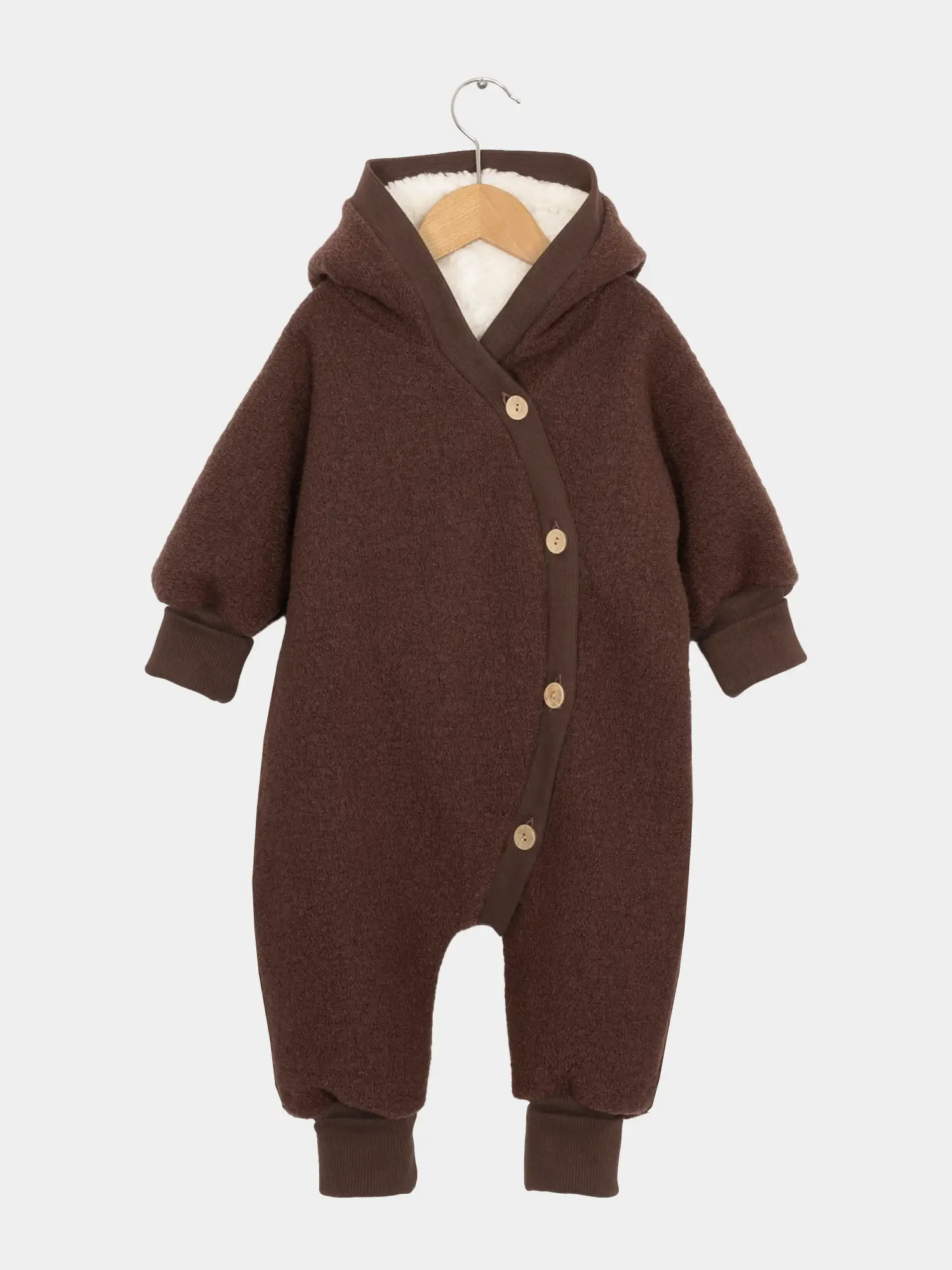 Teddy-Kuschelanzug Wollwalk - Schoko: Dunkelbrauner Baby-Overall mit Kapuze, weichem Teddyfutter. Holzknöpfe asymmetrisch, gerippte Bündchen an Armen und Beinen, aus Schurwolle und Bio-Baumwollplüsch, auf Holzkleiderbügel.