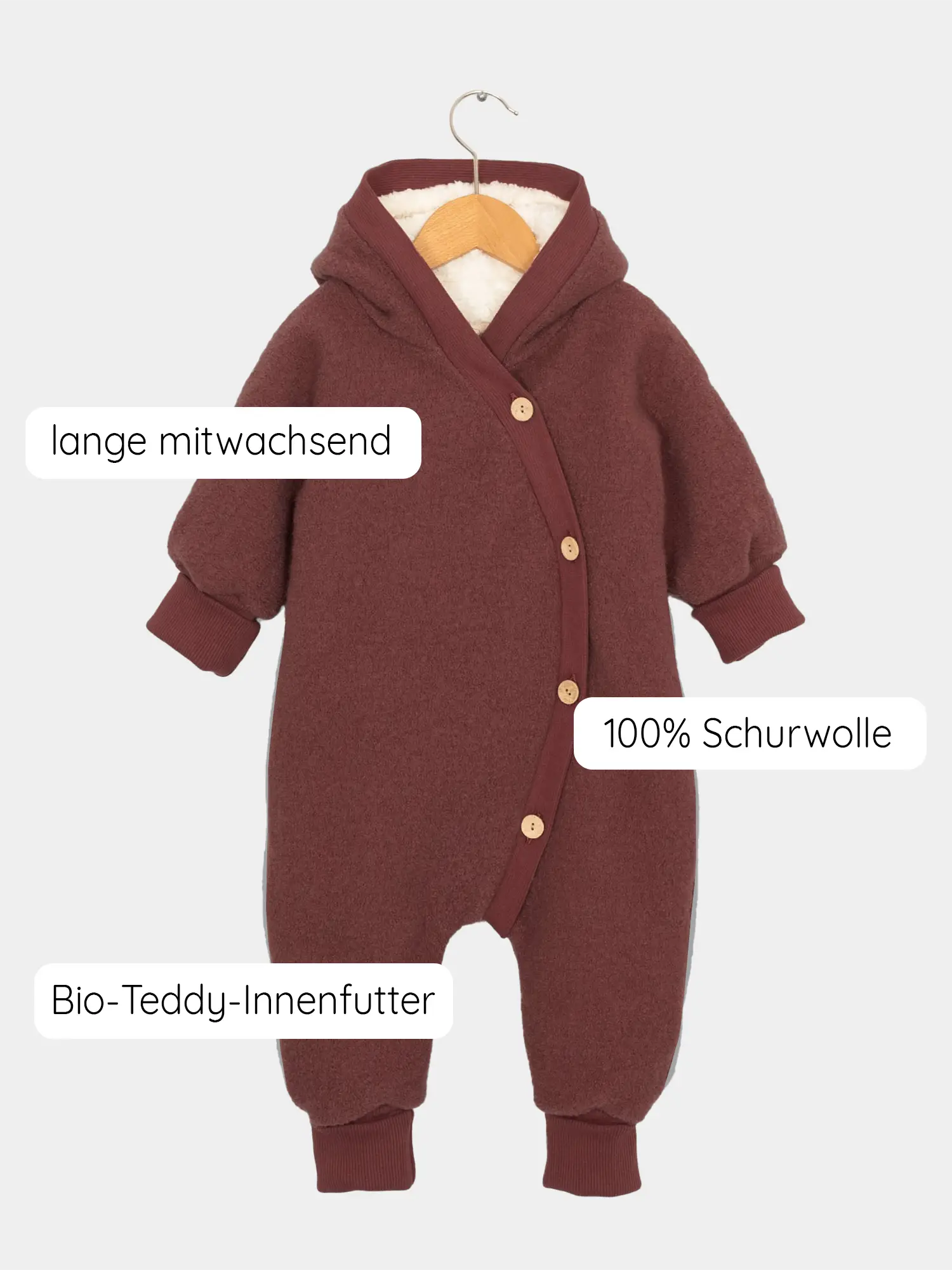 Baby-Overall Teddy-Kuschelanzug Wollwalk - Ziegel aus 100 % Schurwolle, mit Bio-Teddy-Innenfutter. Hängend an Holzkleiderbügel, mit seitlichen Knöpfen und umschlagbaren Bündchen für mitwachsende Länge.
