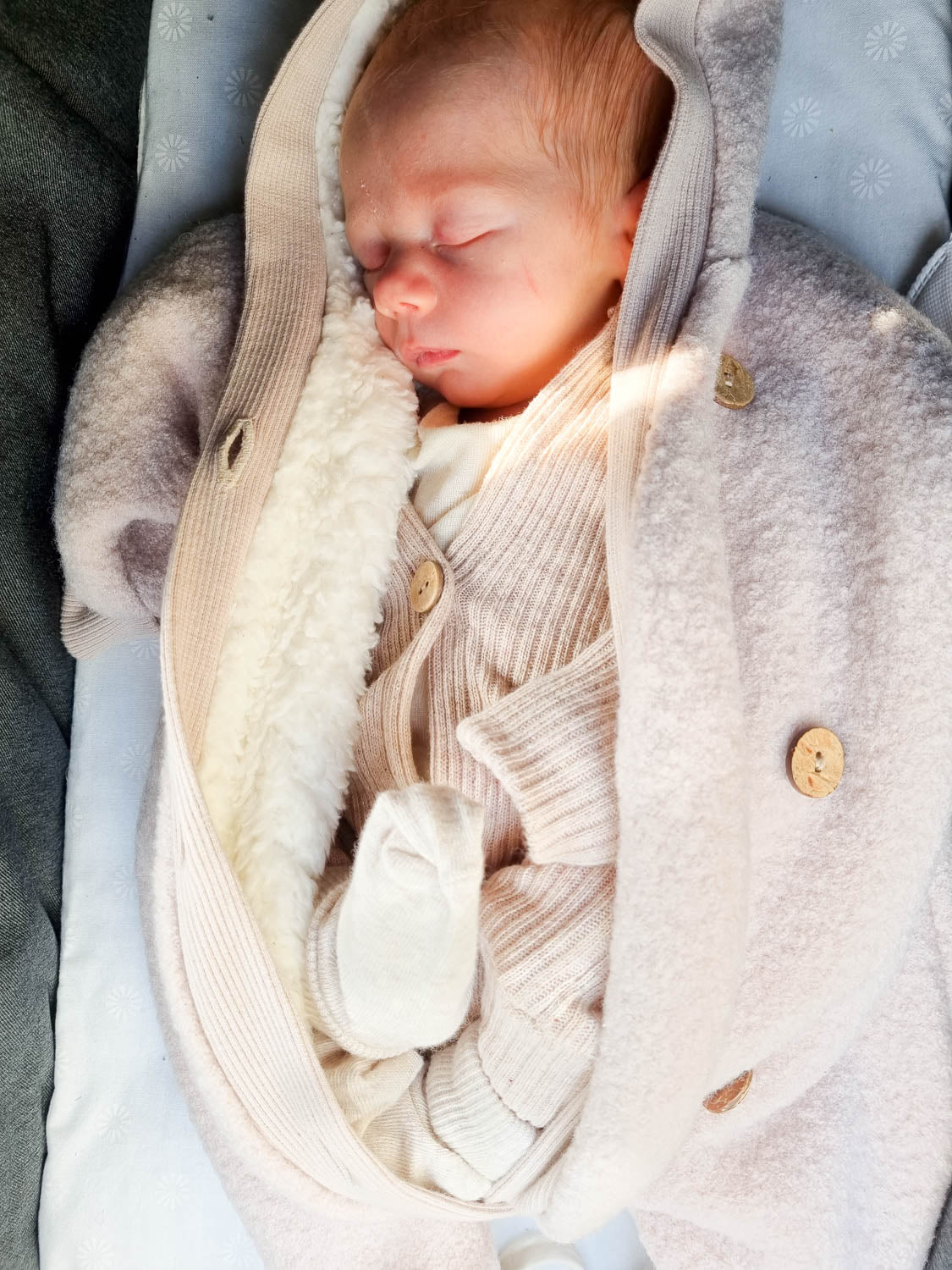 Sleeping baby in a teddy fleece wool overall – Sand, wrapped in a soft wool overall with teddy lining, wooden buttons, and wide cuffs, snowsuit for babies.