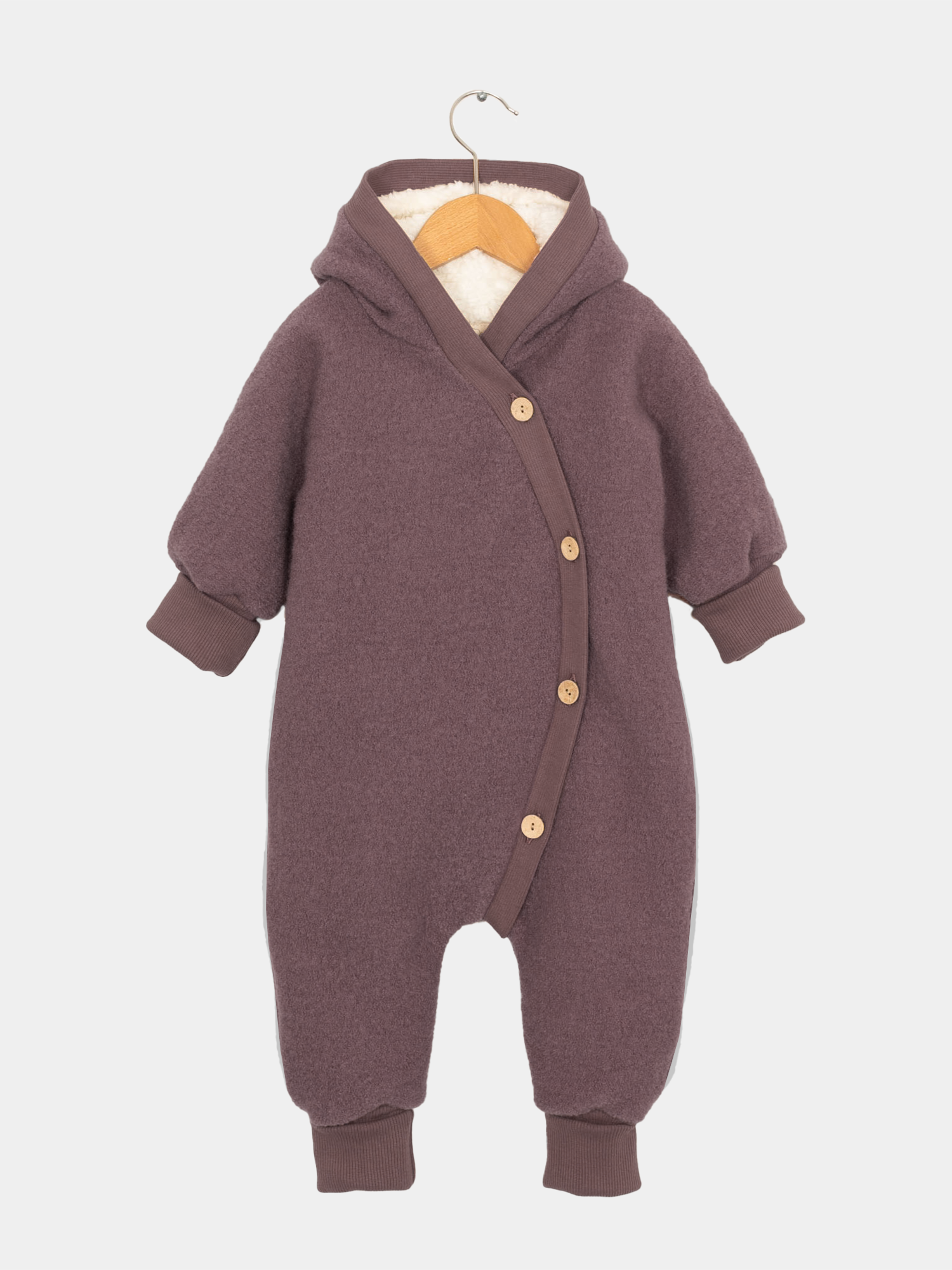 Teddy-Kuschelanzug Wollwalk - Malve: Ein lila Baby-Romper mit Knöpfen und Teddyfutter, ideal für Wintertage, präsentiert auf einem Bügel.