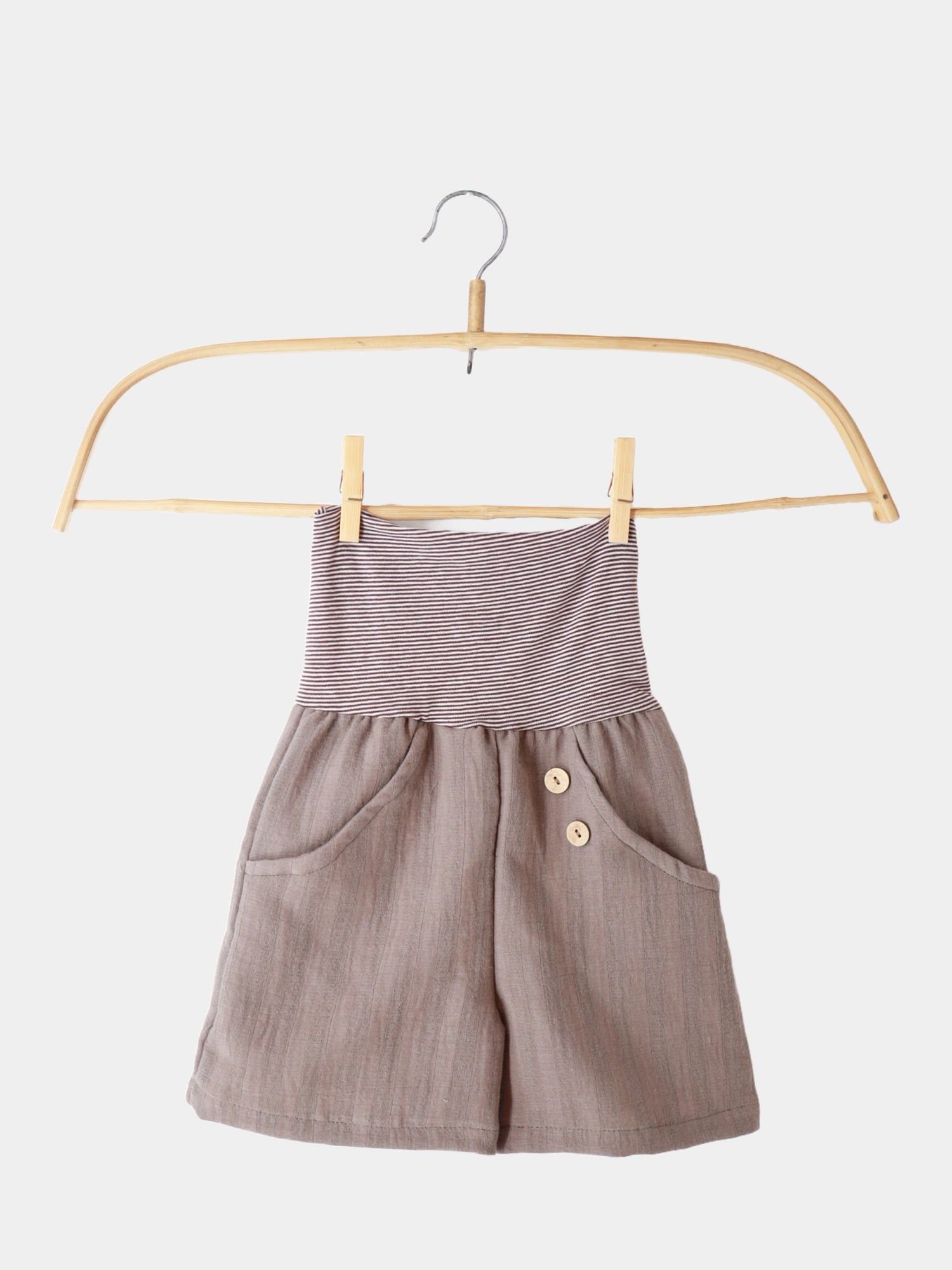 Kurze Buxe Musselin - Praline: Ein Paar bequemer Shorts mit Ringelbündchen, aus 100% Baumwolle, auf einem Kleiderbügel präsentiert, ideal für den Sommer und nachhaltig in Berlin gefertigt.