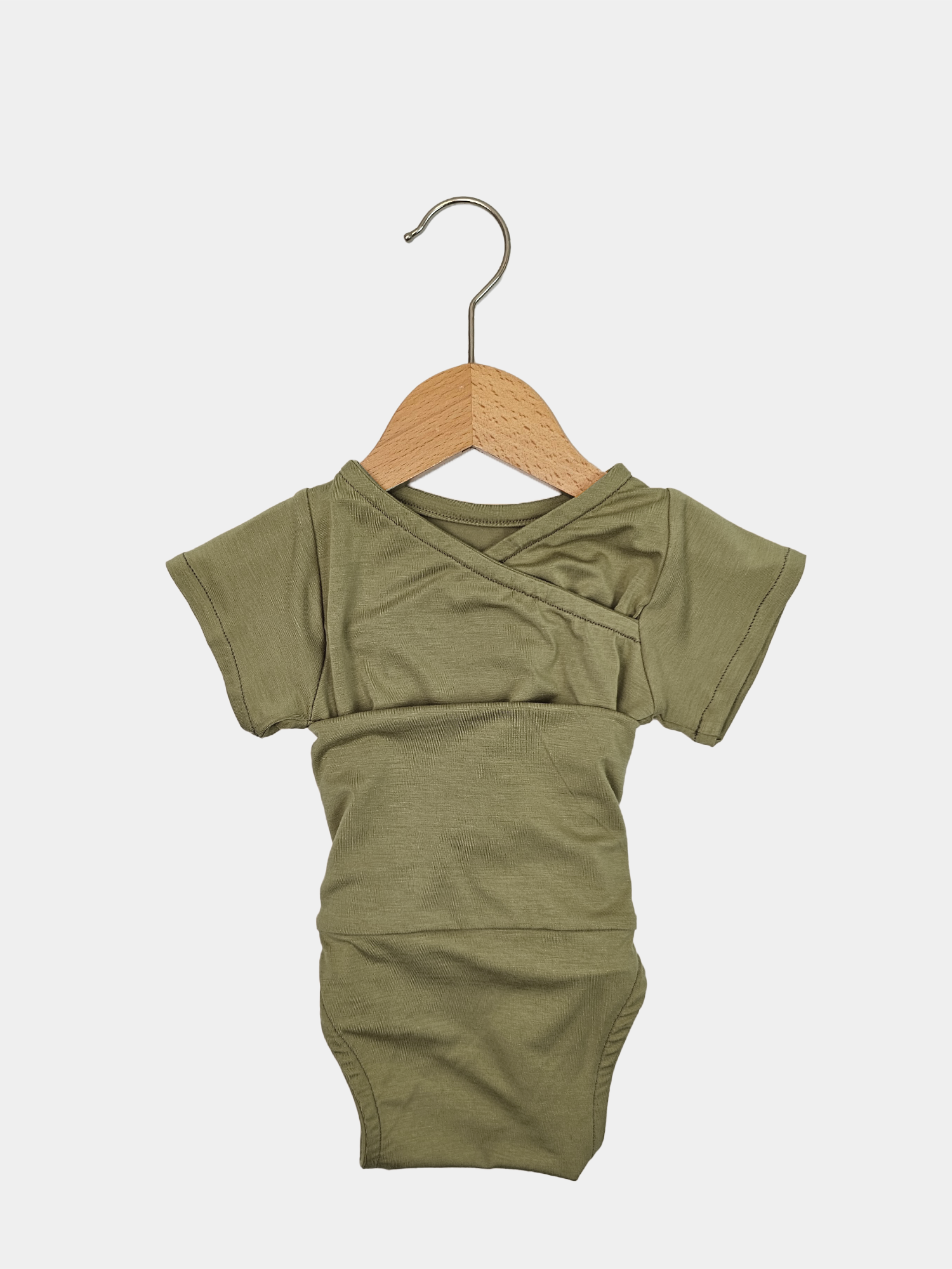 Kurzarm Loopbody Bambusviskose - Olive auf einem Bügel, super Baby Geschenke,  Bild zeigt den elastischen, knopflosen Body mit patentiertem Loop-Design für einfaches An- und Ausziehen.