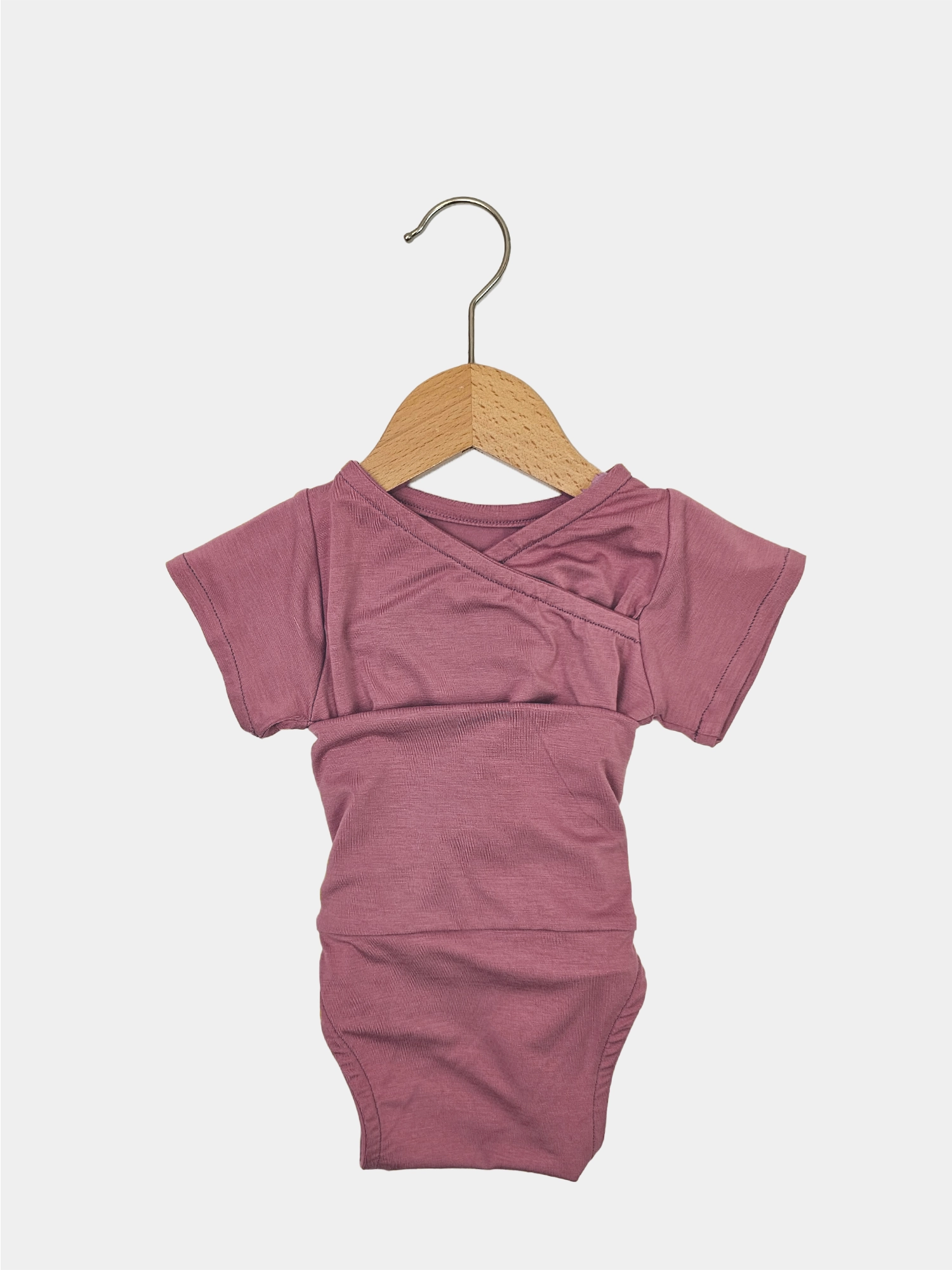 Kurzarm Loopbody Bambusviskose - Beere hängt auf einem Holzkleiderbügel; weiches, elastisches Material, ideal für den Sommer, ohne Knöpfe, Baby Geschenke von PETIT COCHON.