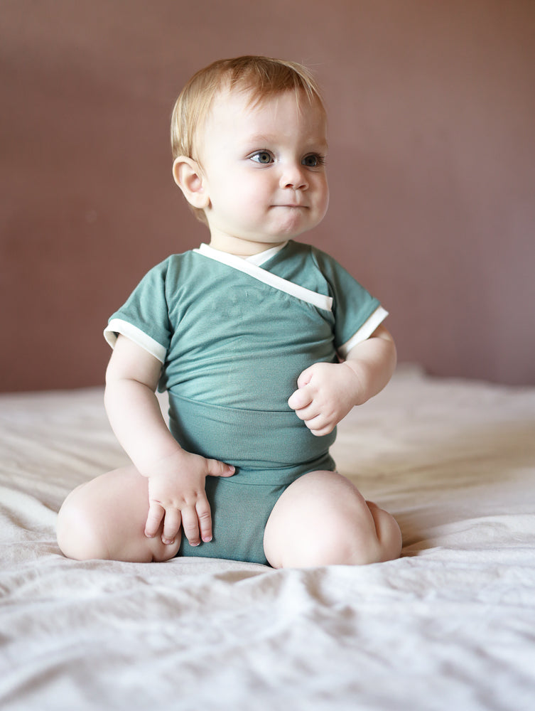 Kurzarm Loopbody Bambusviskose - Türkis: Ein babyfreundlicher Body ohne Knöpfe, aus weicher und elastischer Bambusviskose. Perfekt für den Sommer, schmiegt sich sanft an und erleichtert das An- und Ausziehen.