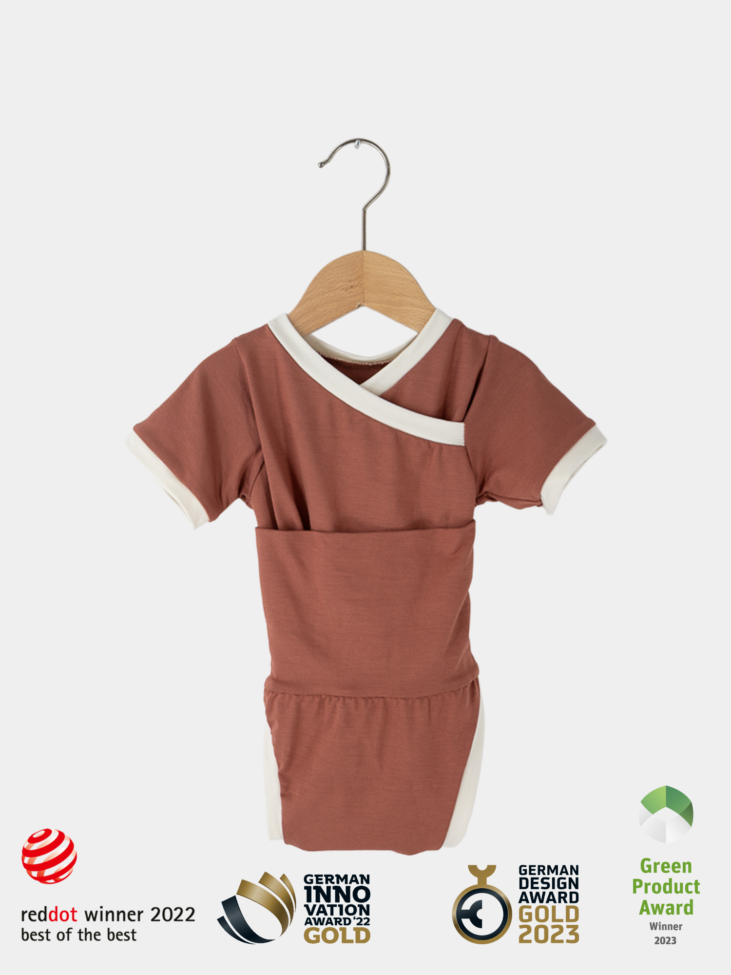 Kurzarm Loopbody Bambusviskose - Pfirsich: Nahaufnahme eines roten und weißen Babybodys auf einem Holzbügel, mit innovativem Loop-Design, das den Bauch sanft umschließt, ohne zu drücken.