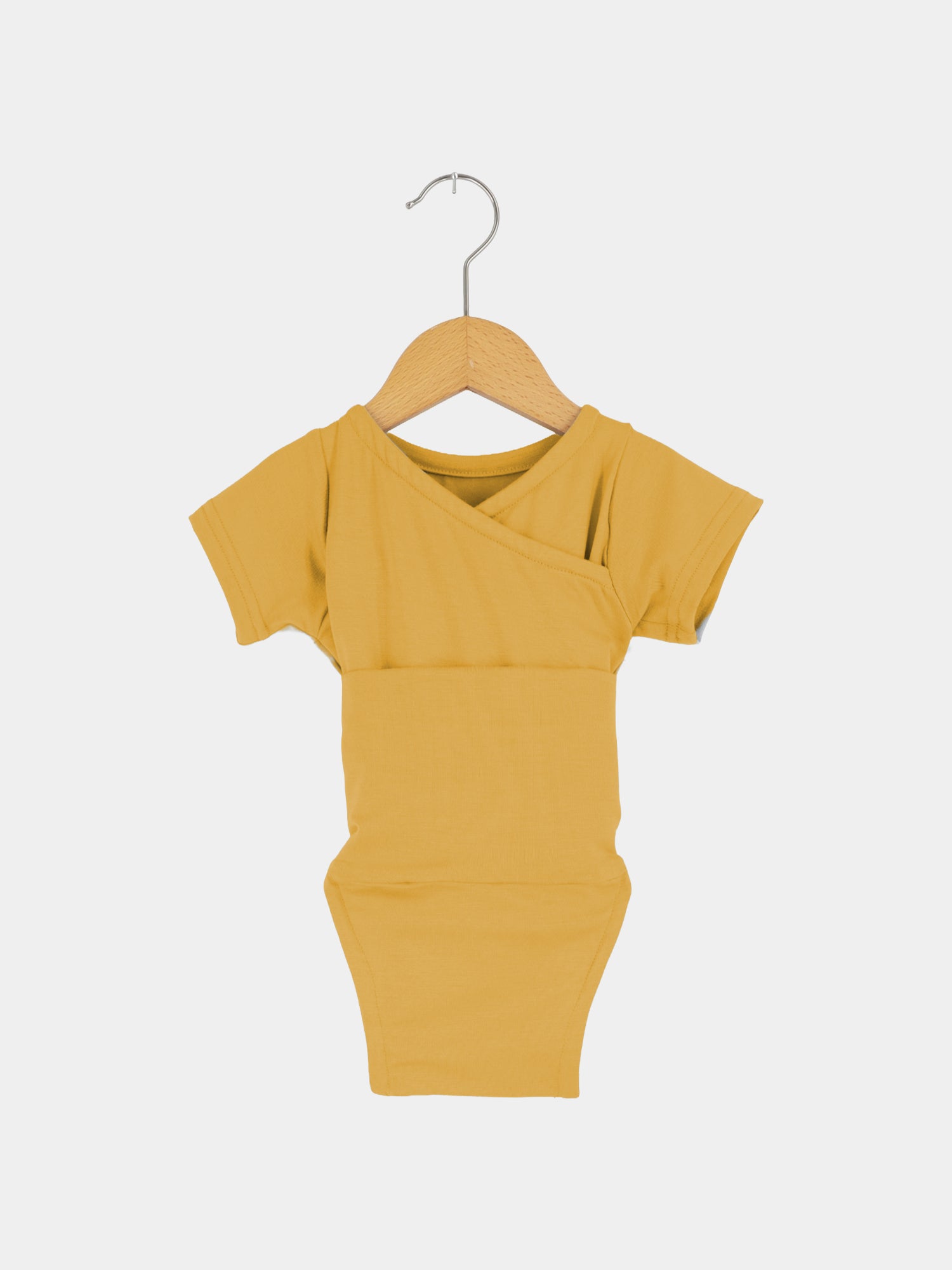 Kurzarm Loopbody Bambusviskose - Honig: Ein weicher, kurzärmeliger Baby-Body aus Bambus in sommerlichem Honigton, auf einem Holzkleiderbügel hängend, ideal für warme Tage, atmungsaktiv und elastisch.