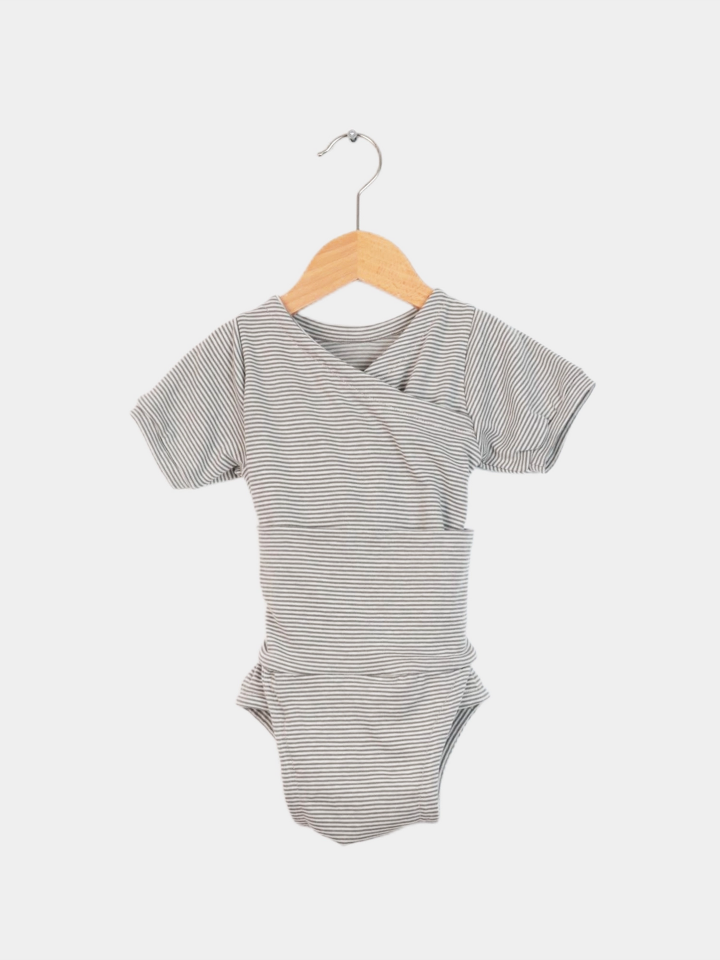 Der Loopbody Kurzarm Bio-Baumwolle - Ringel Maus zeigt einen kurzärmeligen, grau-weiß gestreiften Babybody, der auf einem Holzbügel hängt, ideal für warme Sommertage durch seine atmungsaktive Bambusqualität.