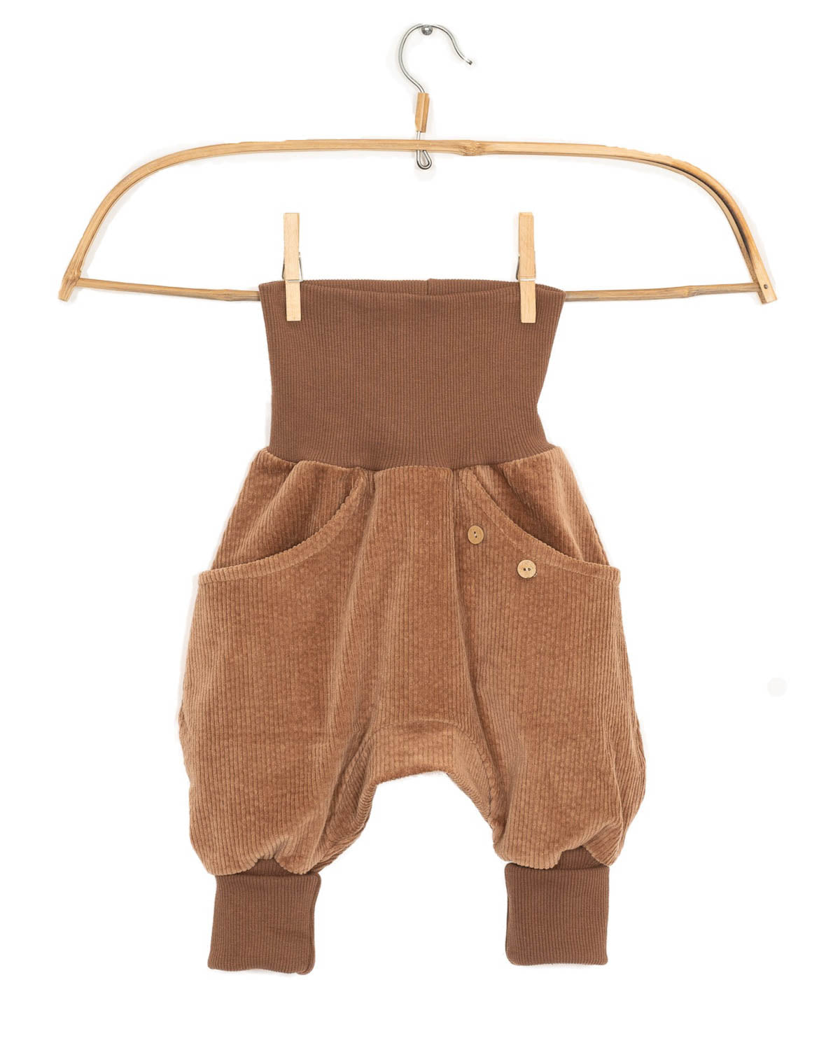 Knickerbocker Breitcord Weizen Gr. 4/5: Kinderhosen im Harem-Stil aus braunem Cord, mit hohem, geripptem Bund, passenden Bündchen und Holzknopf-Taschen, präsentiert auf einem schlichten Holzkleiderbügel.