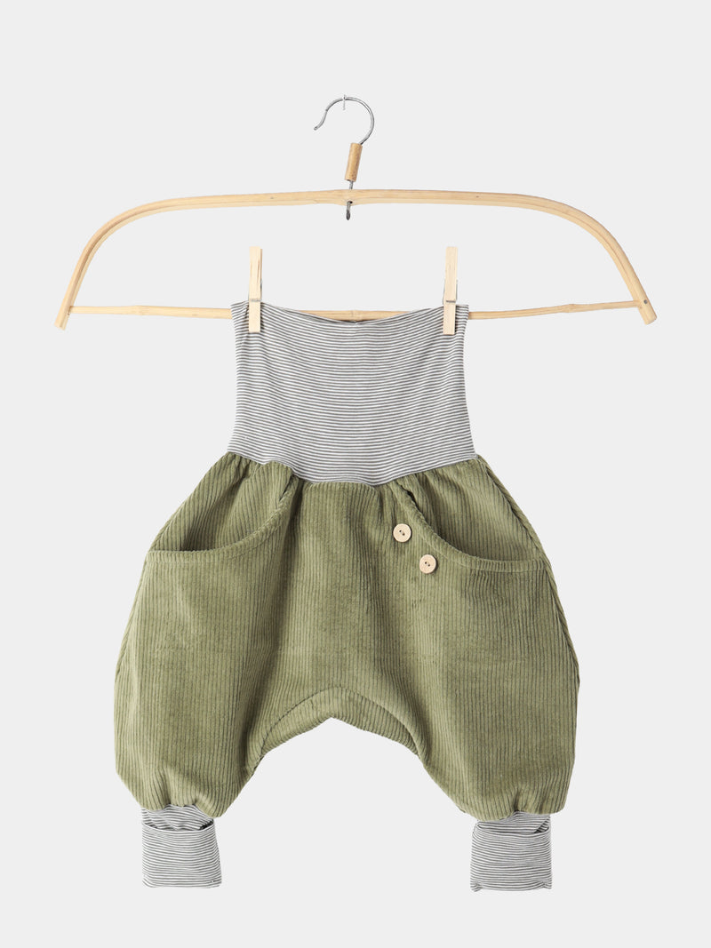Knickerbocker Breitcord Stretch mit Ringelbündchen - Kiwi: Ein olivegrüner Cord-Romper mit gestreiftem Bund und Knöchelbündchen, zwei vorderen Taschen mit Holzknöpfen, hängend an einem Holzkleiderbügel.