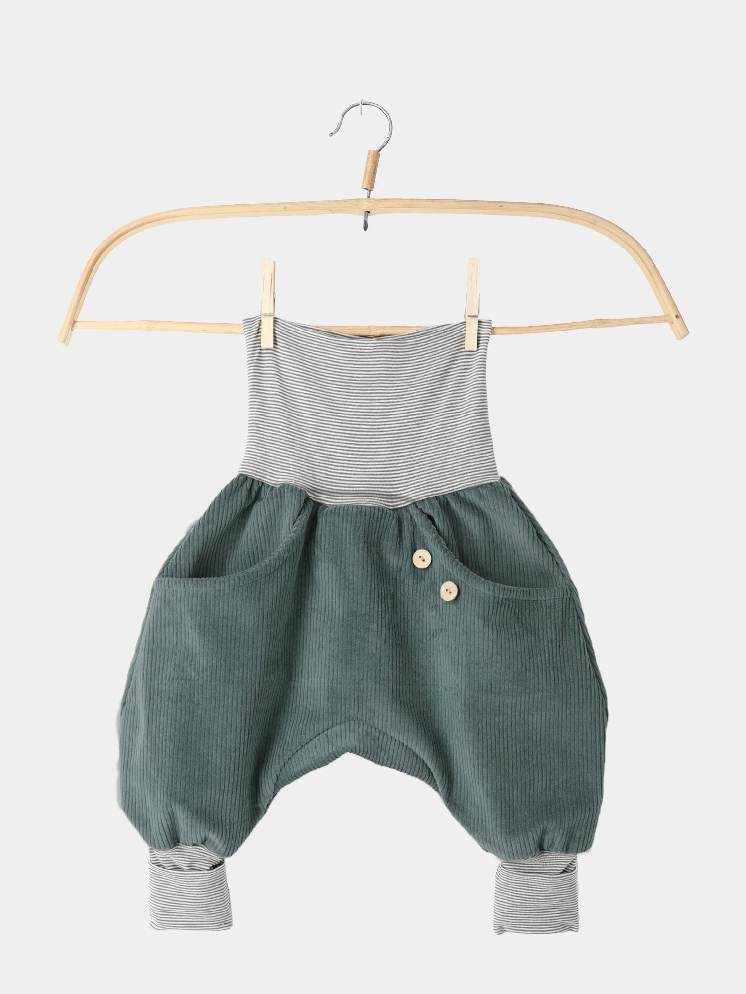 Knickerbocker Breitcord mit Ringelbündchen - Jade: Teal-grüne Cordhose mit gestreiften Bündchen, zwei Taschen, Holzknöpfen, auf Holzkleiderbügel, minimalistischer Hintergrund. Perfekt für Bewegungsfreiheit und praktischen Komfort.