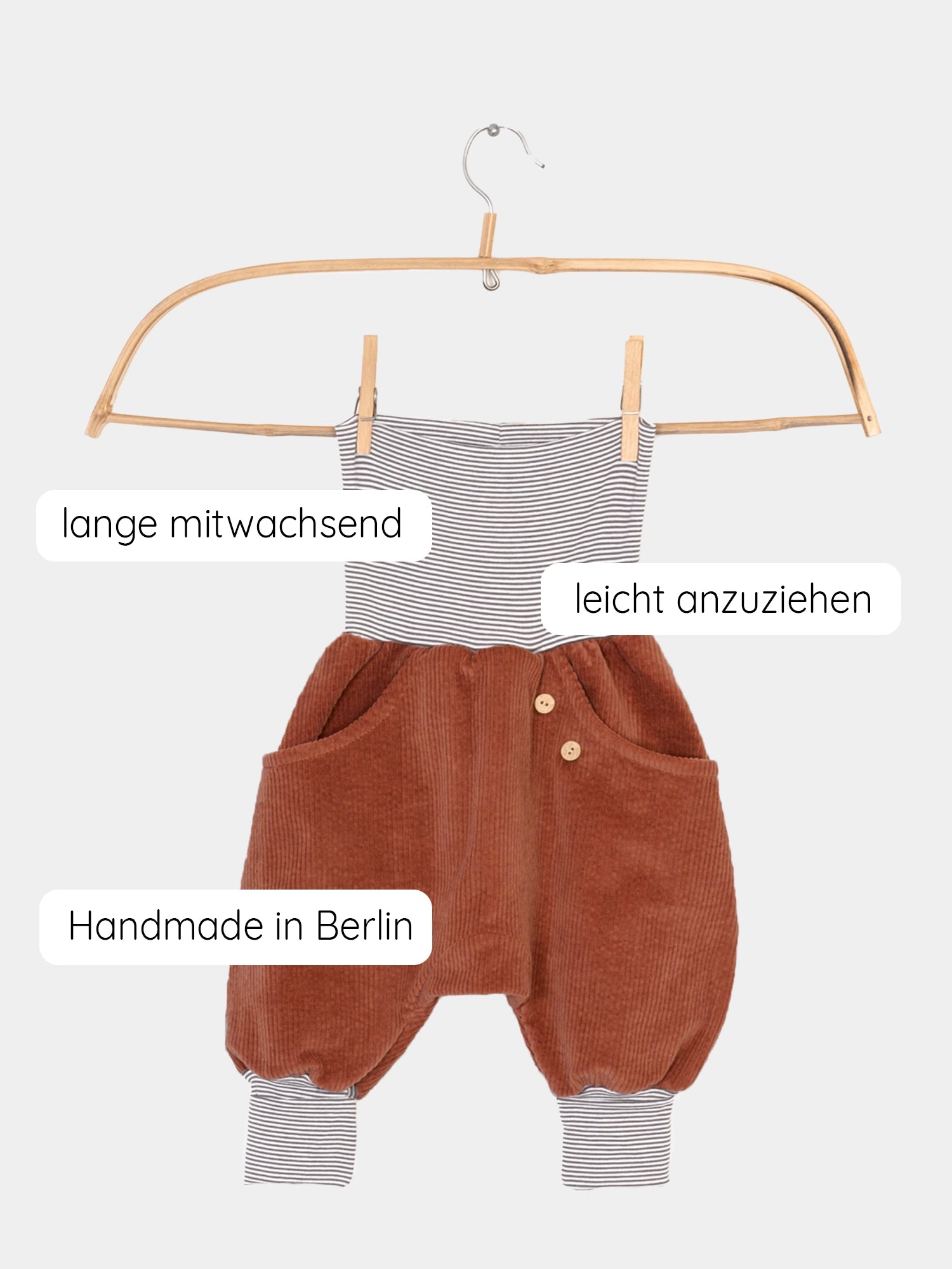 Knickerbocker Breitcord mit Ringelbündchen - Rost: Ein Kleiderbügel zeigt die weiche, elastische Cordhose mit Oversized-Schnitt und Känguru-Tasche, ideal für Bewegungsfreiheit und Komfort, gefertigt in Berlin.
