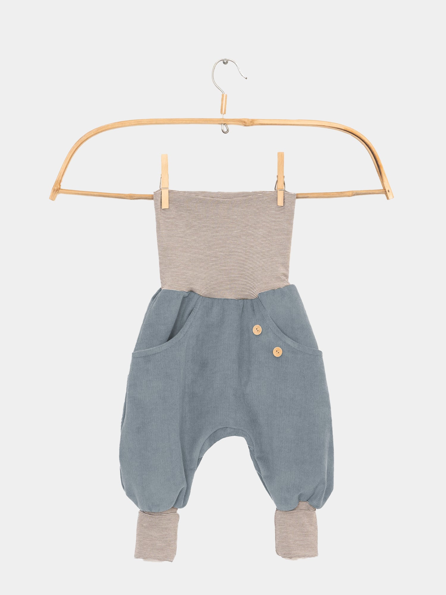 Knickerbocker Feincord Ringel - Himmelblau: Einteiler mit gestreiftem Oberteil, himmelblauem Feincord-Unterteil, seitlichen Holzknöpfen, aufgesetzten Taschen und gestreiften Bündchen an den Knöcheln, hängend an einem Holzbügel.